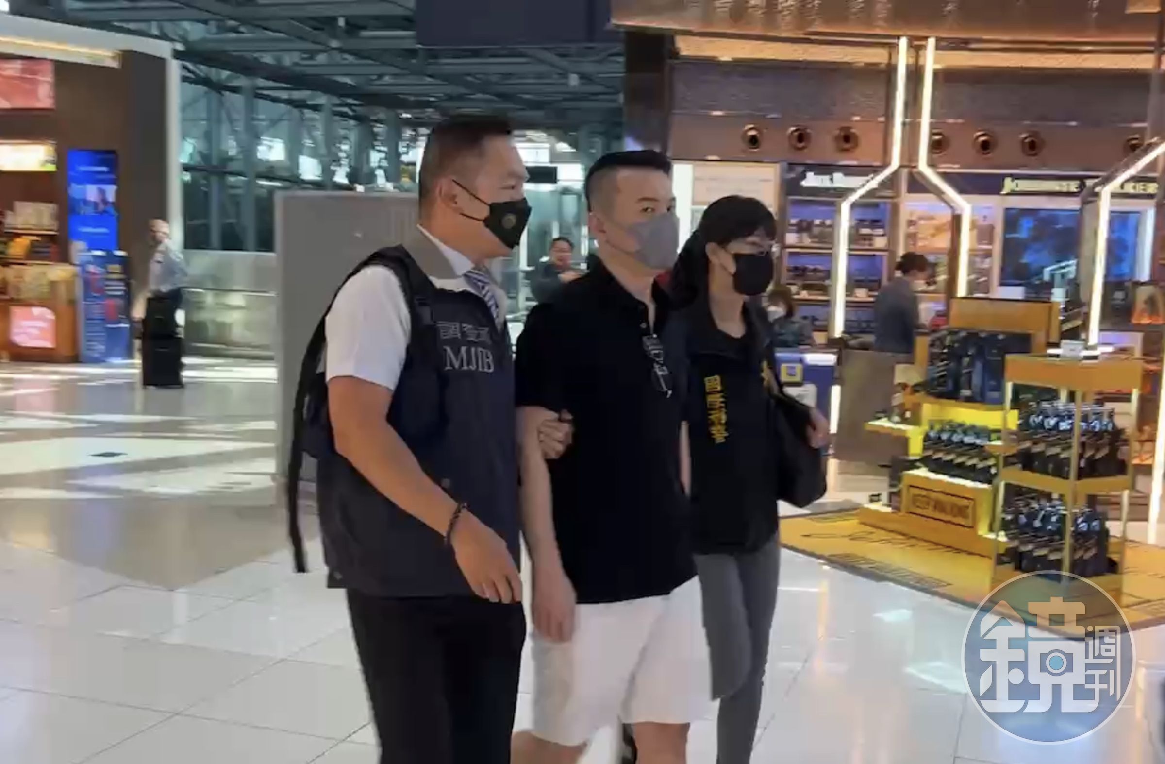 郭哲敏被警方押解搭機。(刑事局提供)