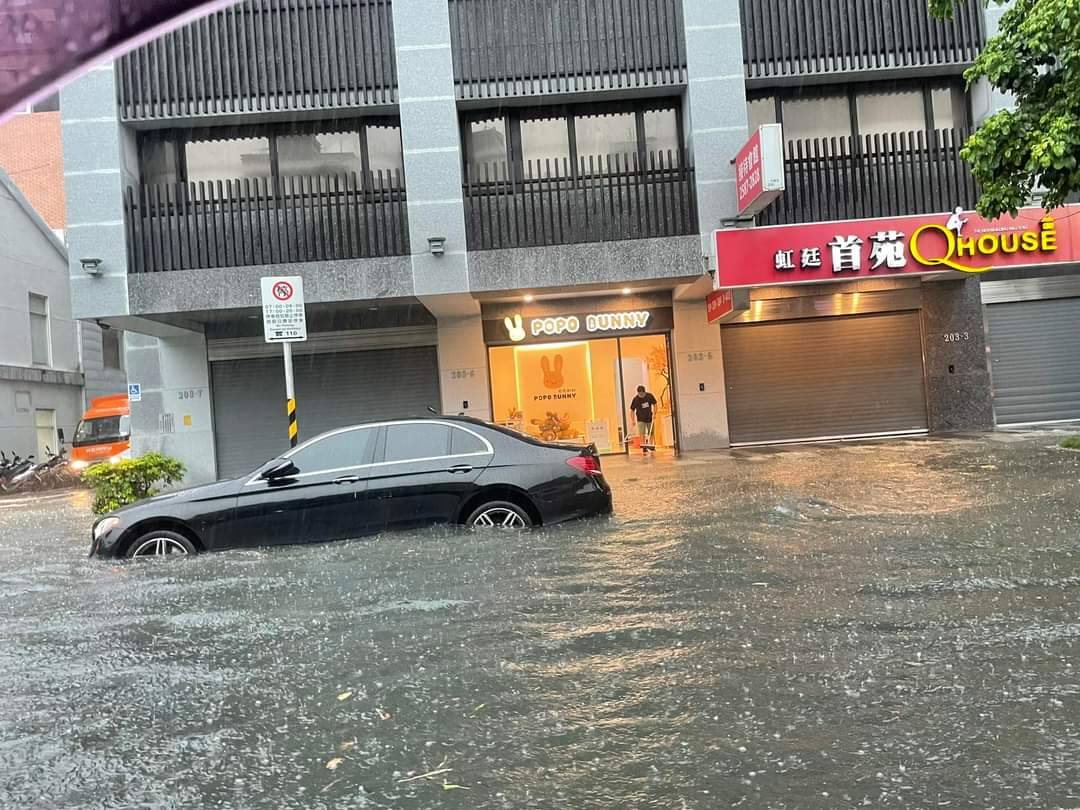 北市重慶北路積水成河,有汽機車駕駛疑似因愛車拋錨下車推行。(翻攝自記者爆料網)