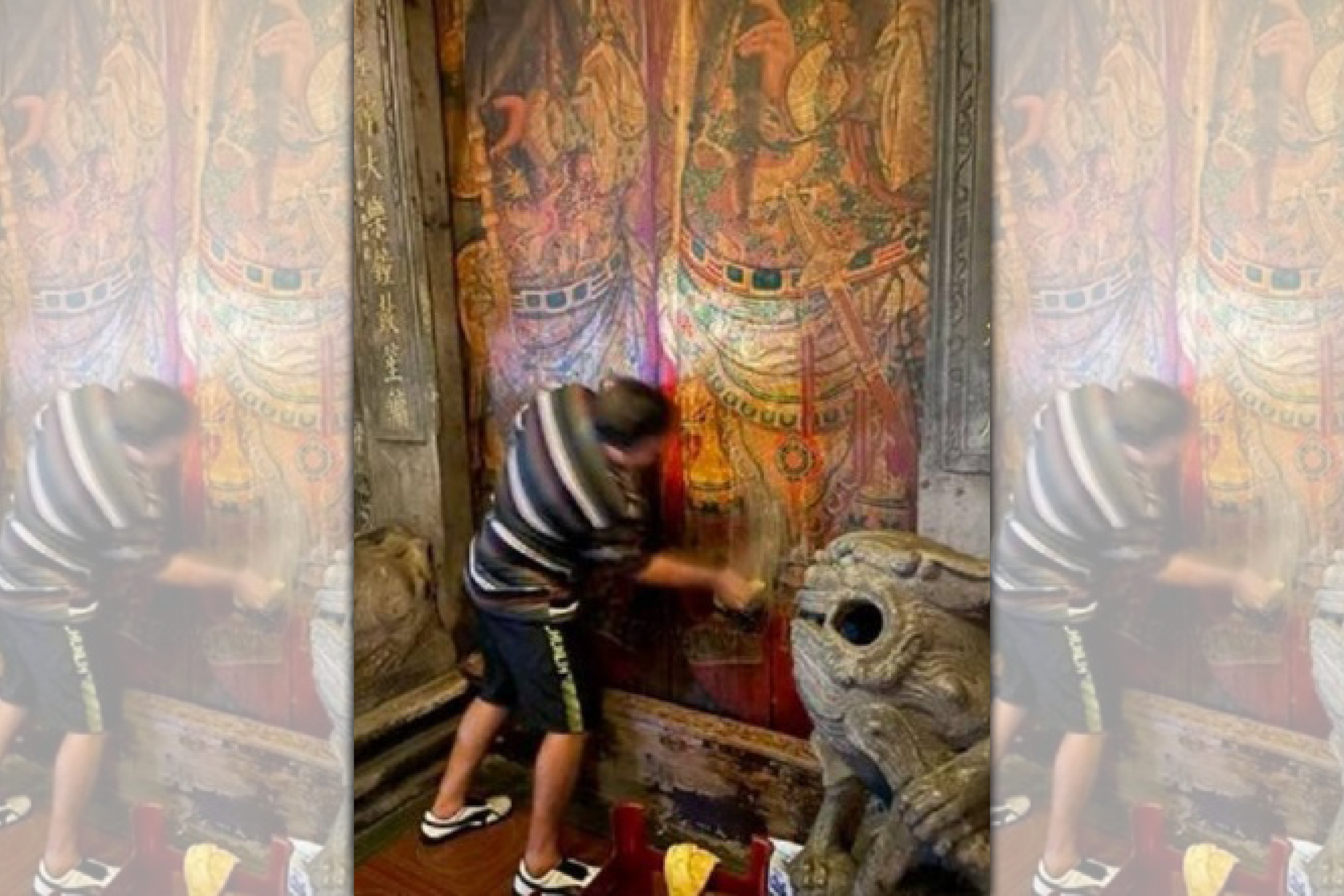 西班牙籍男子拿清潔劑、抹布狂刷古蹟廟門。（翻攝畫面）