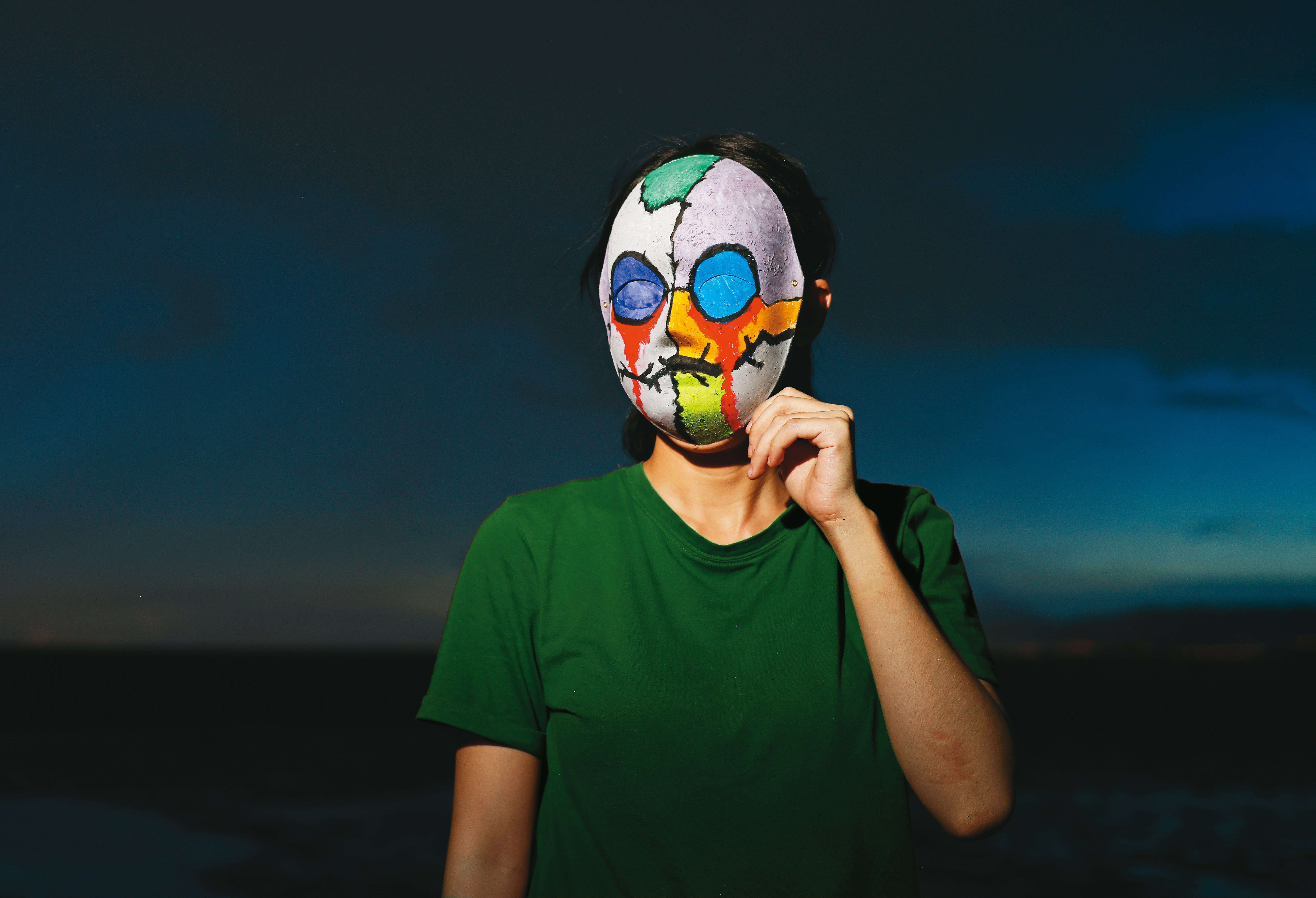 小云戴上親手繪製、象徵自己面貌的面具拍攝。