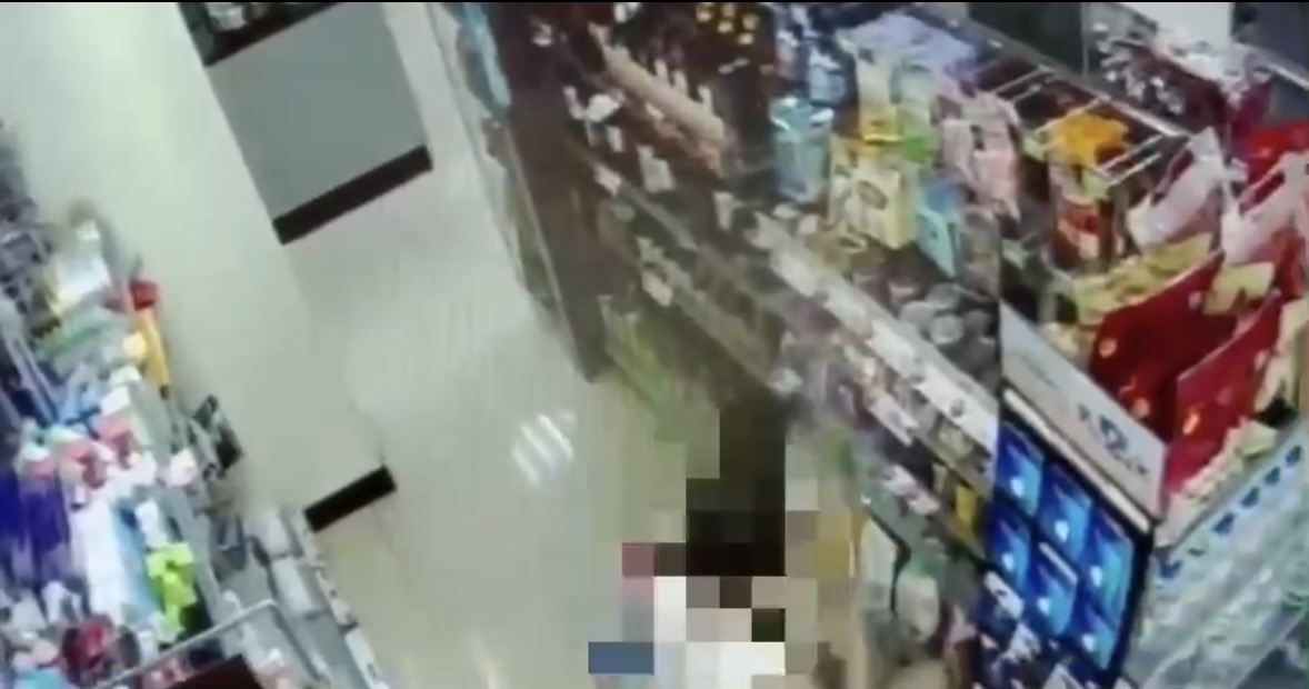 陳女蹲在超商貨架旁，趁隙偷走架上貨品。（翻攝畫面）
