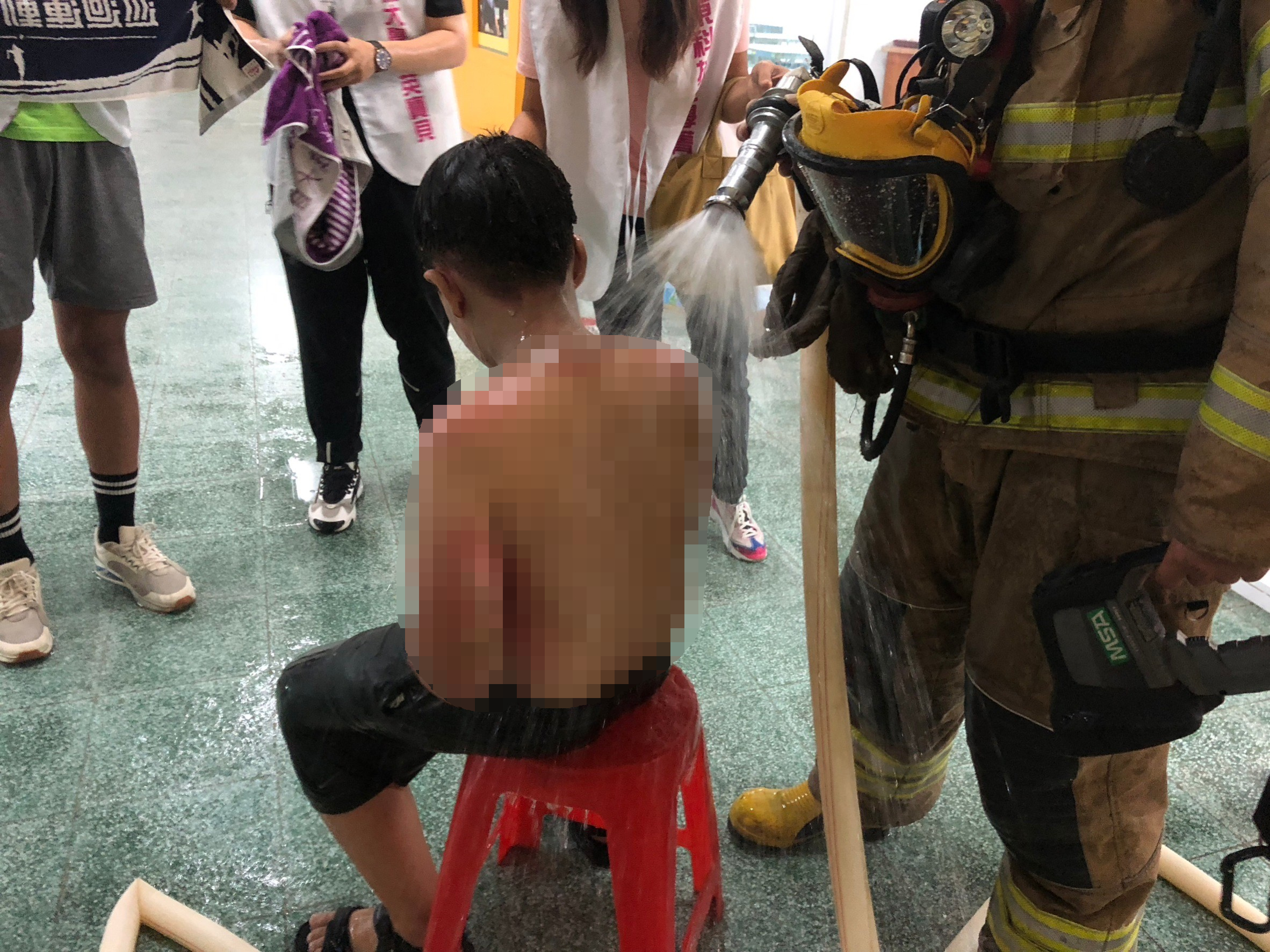 學童參加科學足球營因實驗不慎引發火警遭燒燙傷，消防人員到場後緊急救護。（翻攝畫面）