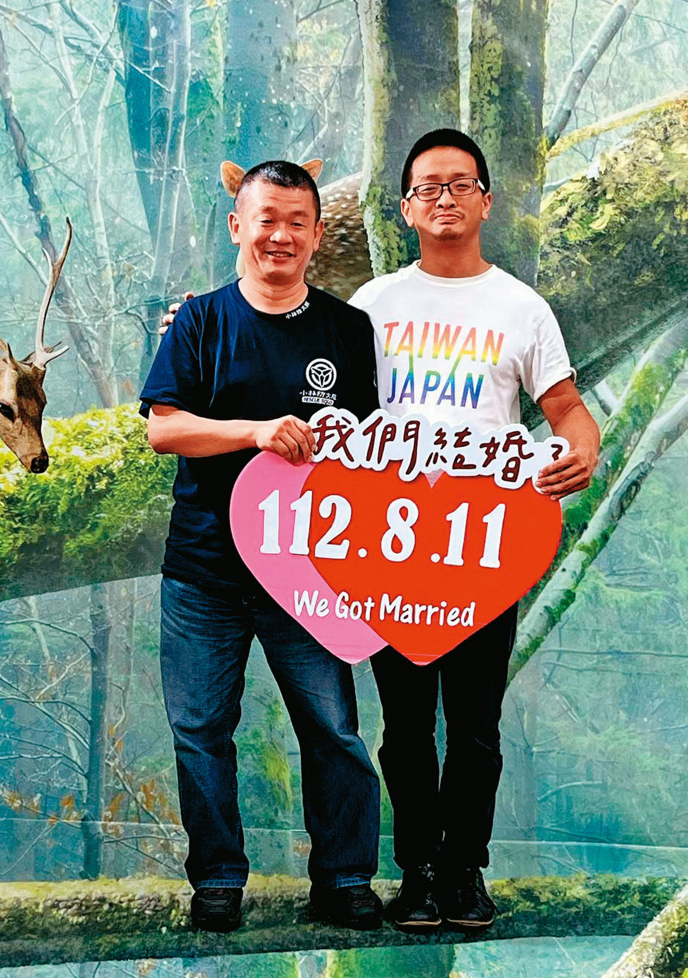 柴口征寬(左)與劉靈均(右)11日在北市大同戶政事務所登記完婚,開心地高舉「我們結婚了」標語。(劉靈均提供)