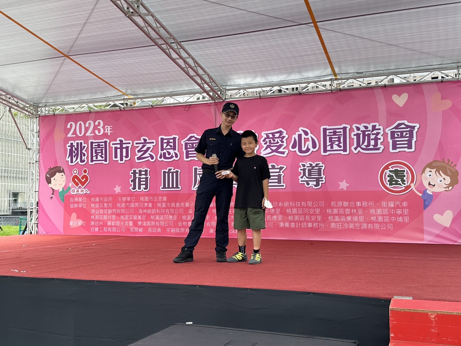 桃園分局與愛心團體合作反毒宣導，員警謝昀融到場與小朋友互動合影。（讀者提供）