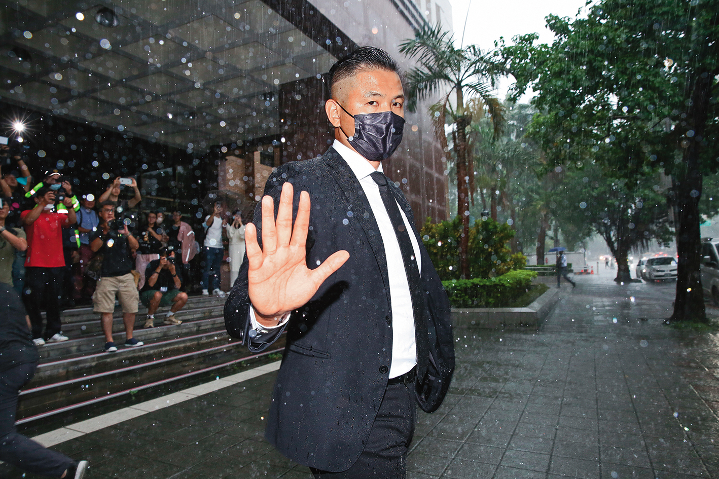 陳建州冒雨赴北檢應訊,淒風苦雨營造慷慨赴義的意境。
