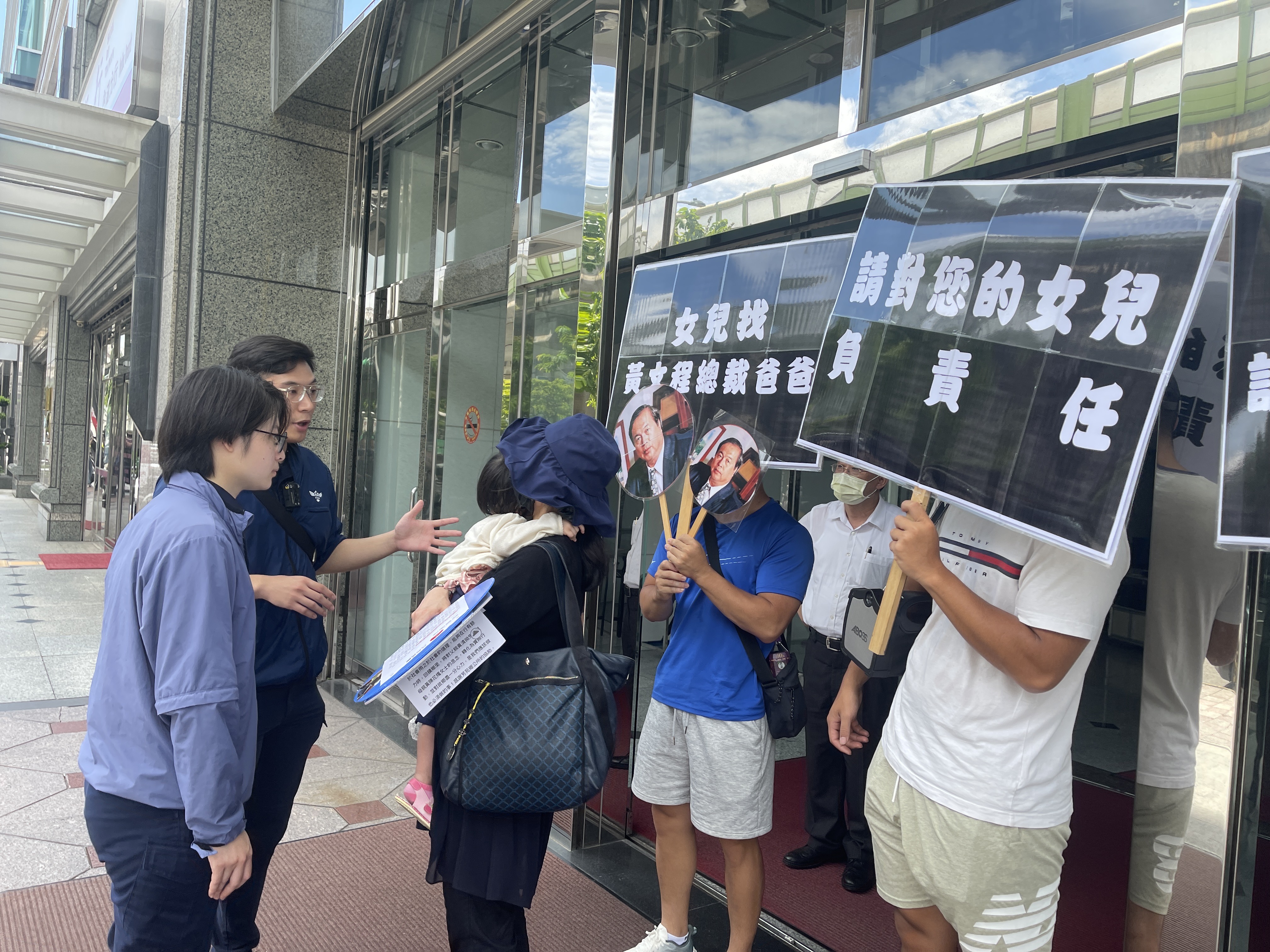 陳女帶著2歲女兒，頂著大太陽在公司門口舉牌抗議，希望黃文程出面處理。