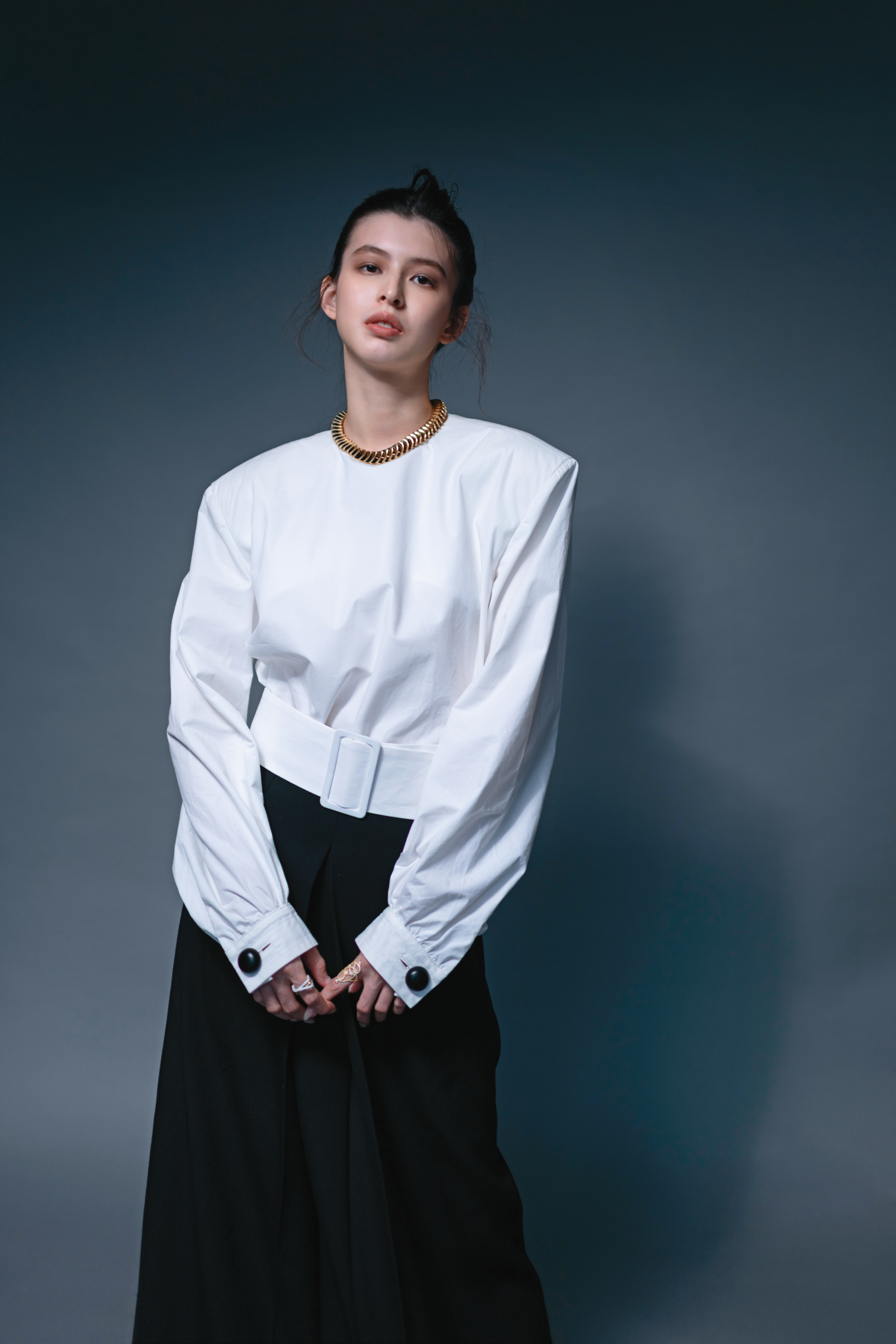 白色寬肩收腰上衣，NT$47,900，by TOD'S；黑色羊毛長裙，NT$39,900，by TOD'S；純銀鍍金鋯石項鍊，價格店洽，by BOTTEGA VENETA；（右）流星交織指環，NT$6,200，by APM MONACO；（左）密鑲長方形交織戒指，NT$8,700，by APM MONACO。