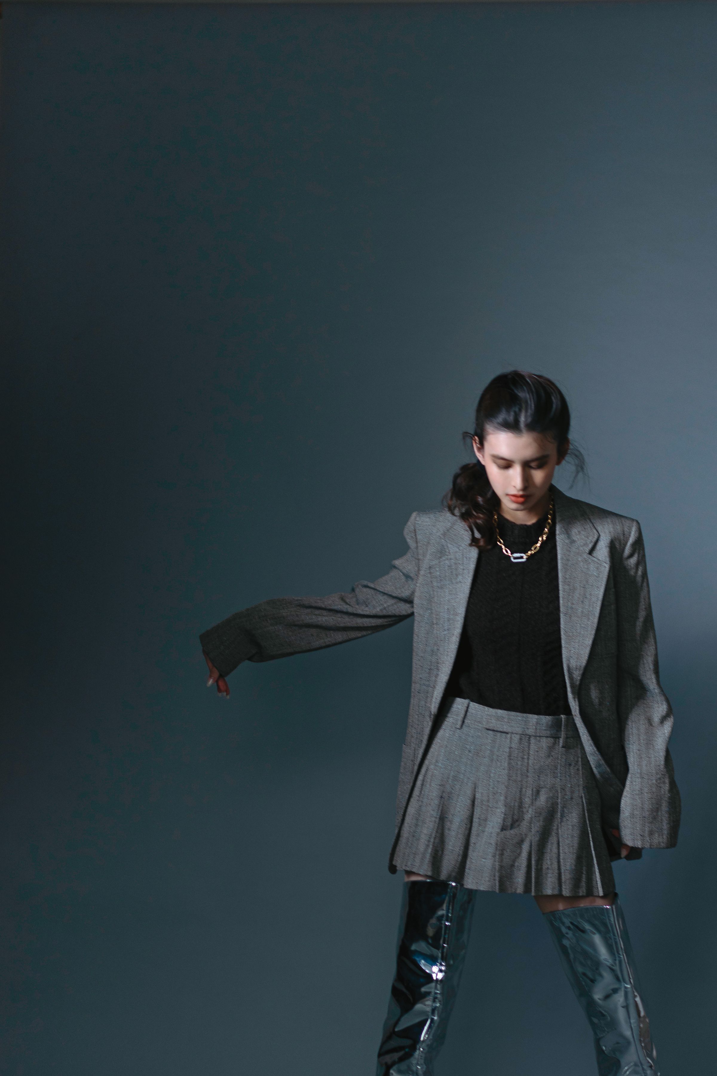 灰色紋理西裝，NT$91,600，by BOTTEGA VENETA；棕色針織毛衣，NT$47,900，by BOTTEGA VENETA；灰色紋理短裙，NT$47,900，by BOTTEGA VENETA；銀色過膝長靴，價格店洽，by BOTTEGA VENETA；密鑲鍊環項鍊，NT$10,000，by APM MONACO。