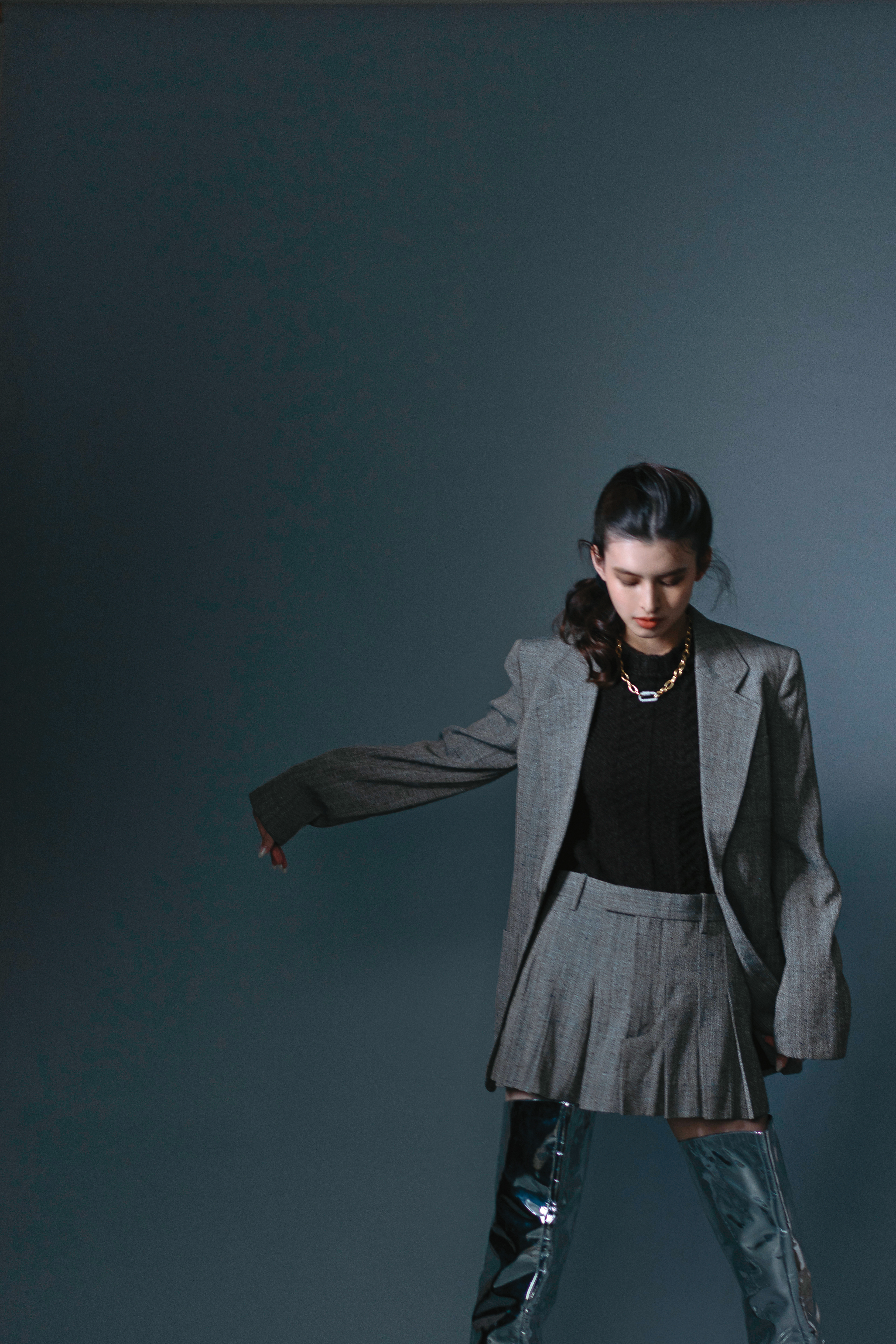 灰色紋理西裝，NT$91,600，by BOTTEGA VENETA；棕色針織毛衣，NT$47,900，by BOTTEGA VENETA；灰色紋理短裙，NT$47,900，by BOTTEGA VENETA；銀色過膝長靴，價格店洽，by BOTTEGA VENETA；密鑲鍊環項鍊，NT$10,000，by APM MONACO。