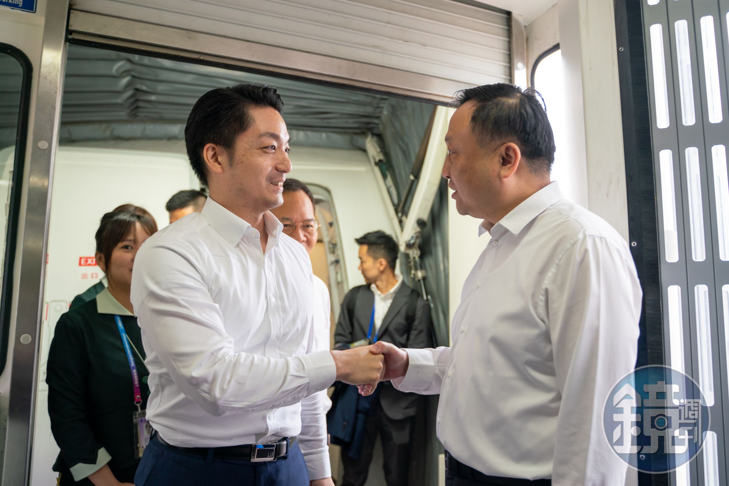 蔣萬安(左)抵達上海後,由上海市副市長華源(右)親自接機,兩人也握手致意。(台北市政府提供)