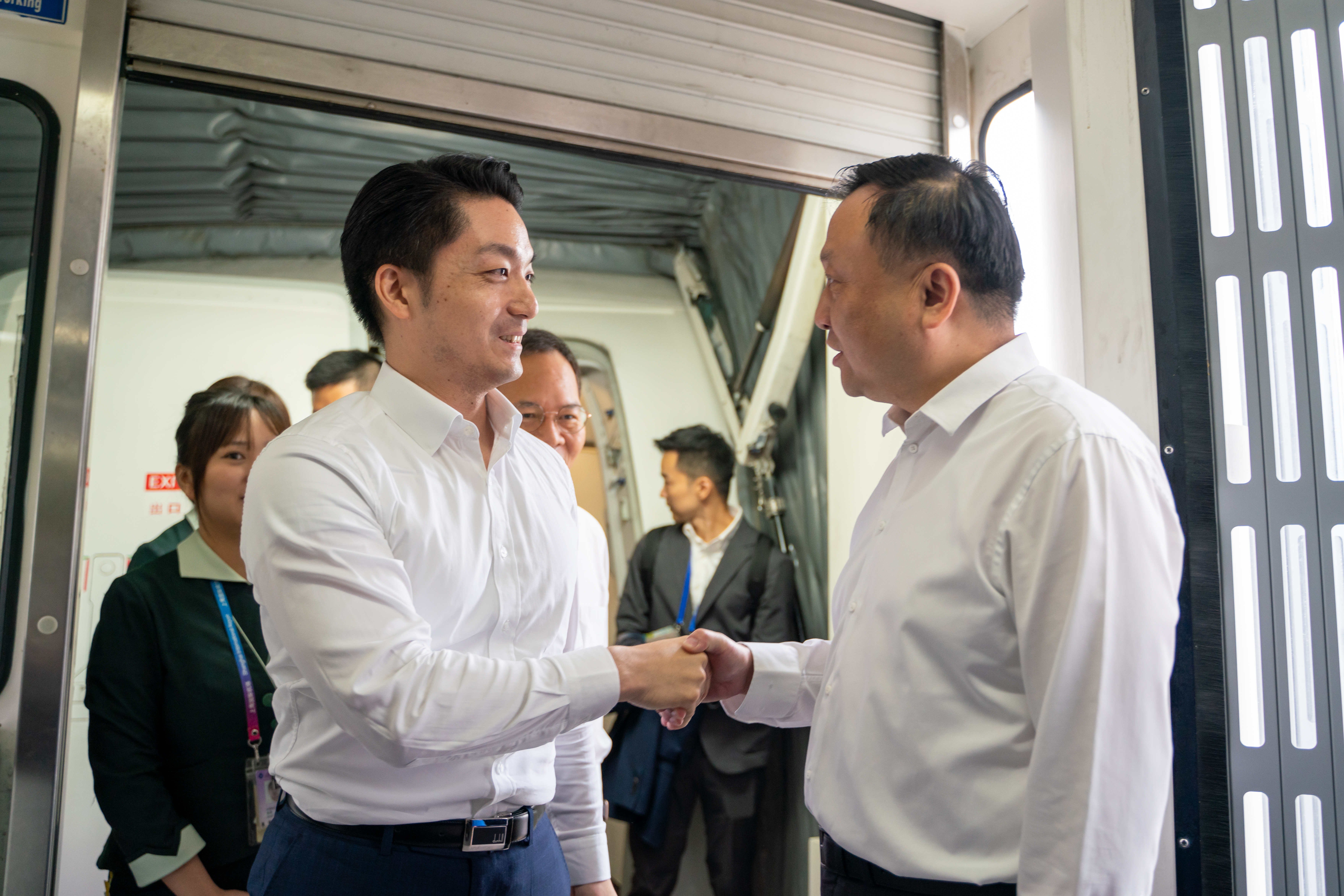 蔣萬安（左）抵達上海後，由上海市副市長華源（右）親自接機，兩人也握手致意。（台北市政府提供）