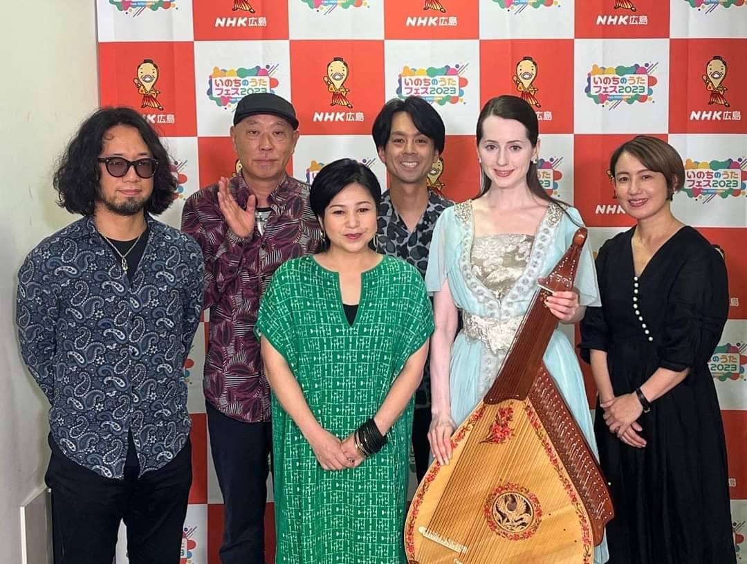 在日發展的烏克蘭歌姬娜塔莎(右2)以烏克蘭傳統樂器班多拉琴伴奏演唱〈淚光閃閃〉。(萬世國際提供)