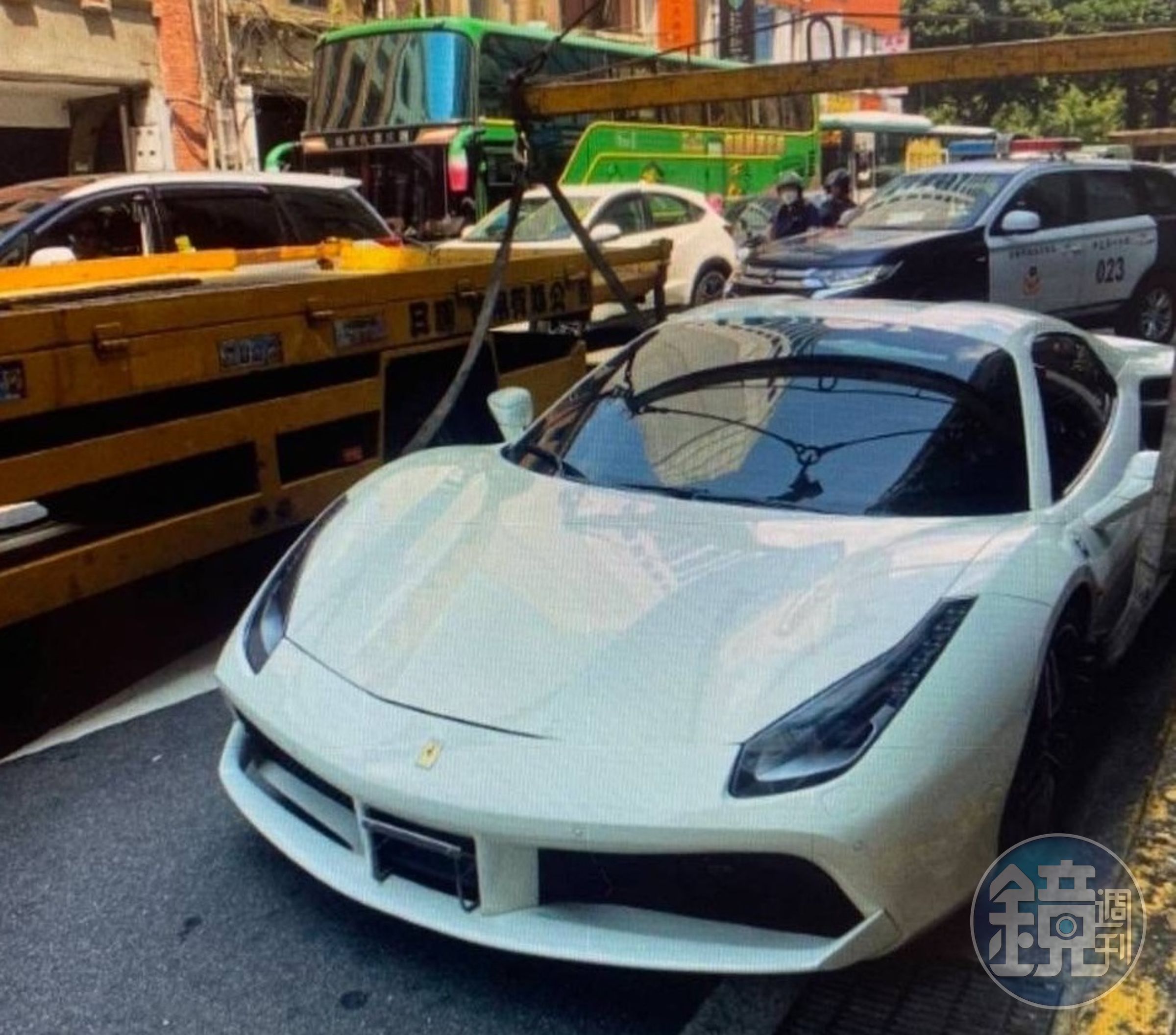 白色法拉利超跑因車牌註銷違規上路,遭警方以大型拖吊車吊走保管。(翻攝畫面)