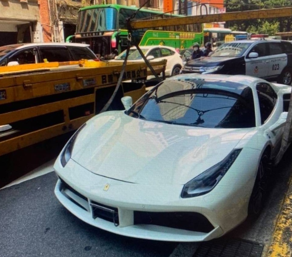 白色法拉利超跑因車牌註銷違規上路，遭警方以大型拖吊車吊走保管。（翻攝畫面）