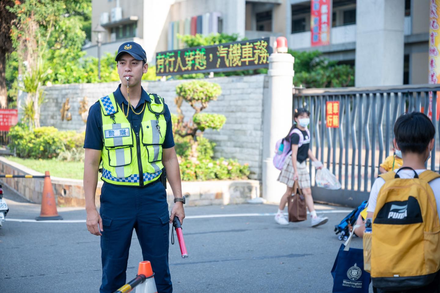 「天菜帥警」站校門守護學童，網友表示：「看到帥警察，媽媽我都想去上課了」。（翻攝自TCPB局長室臉書）
