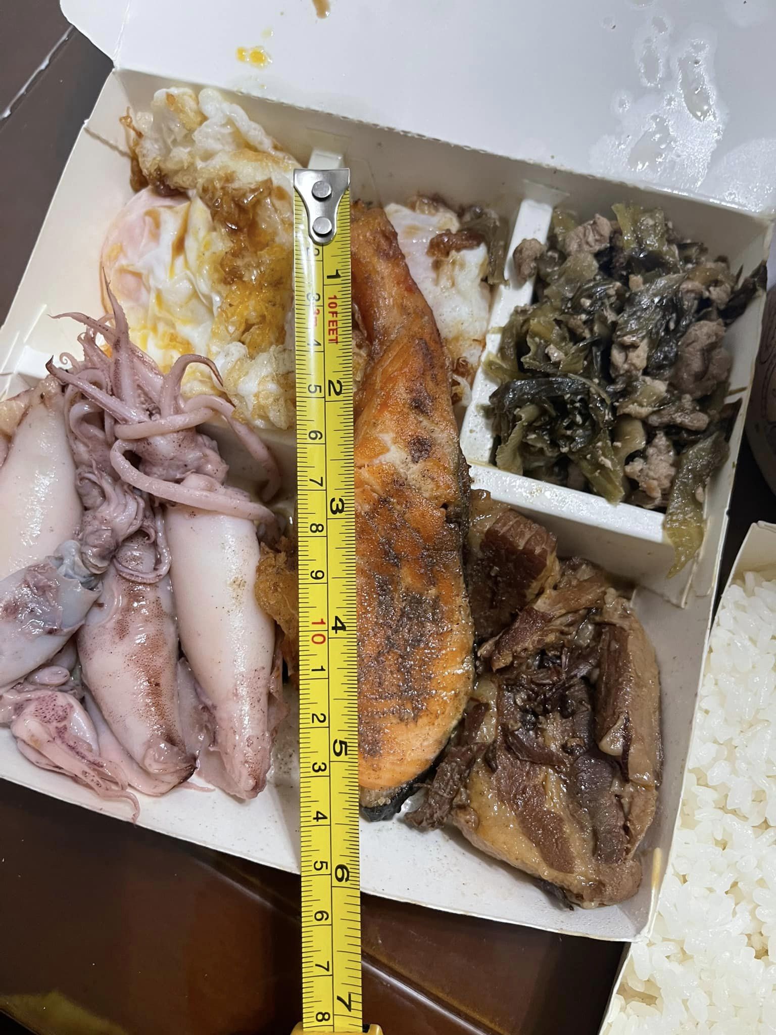 女子還拿出尺量了半片煎鮭魚的長度為13.5公分。(翻攝自臉書社團《新竹大小事》)