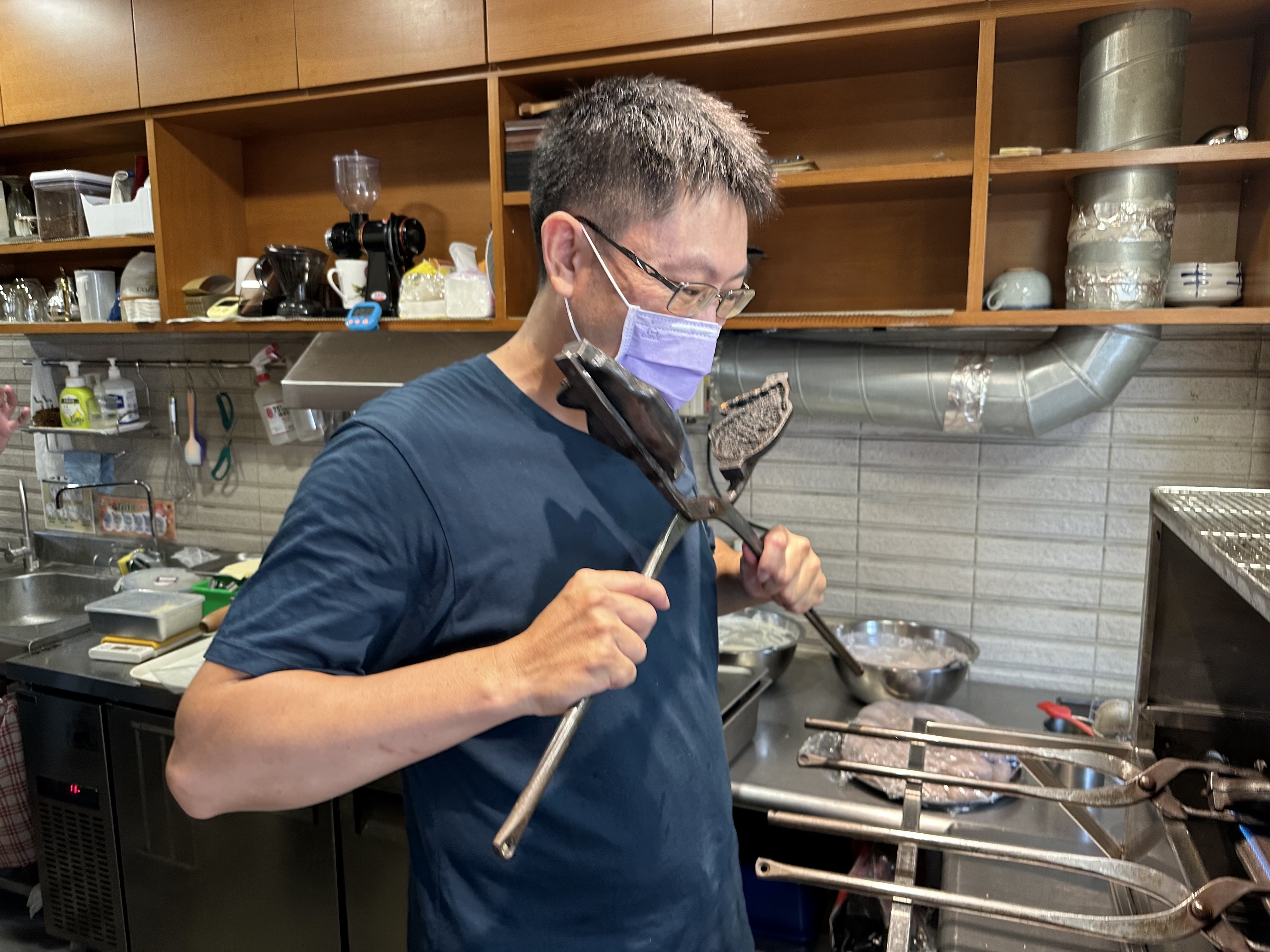 蘇昭安把剪刀式烤具放在臉頰下方感受溫度，確認下麵糊時機。