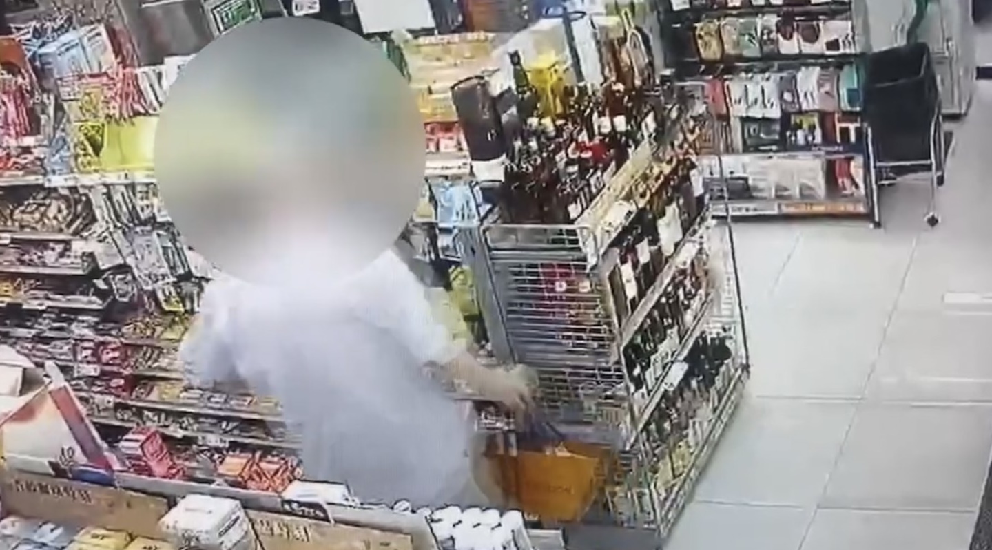 監視器拍下李男從酒類貨架上拿走一瓶威士忌，隨即放進自己口袋裡。（翻攝畫面）