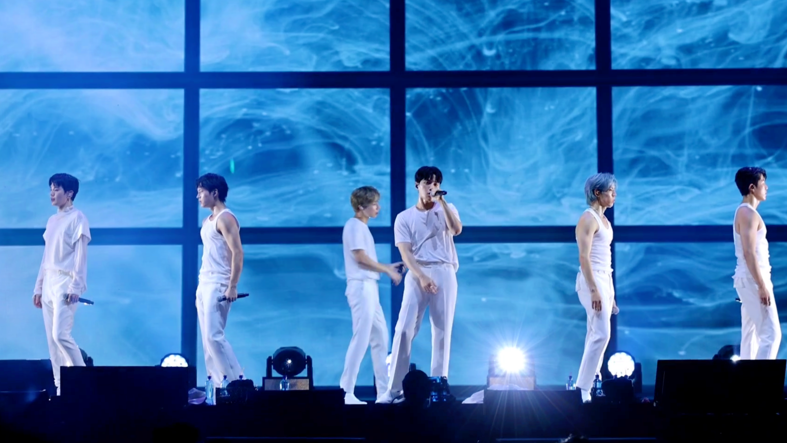 INFINITE表演〈Paradise〉時脫掉西裝外套，優鉉（左二）、東雨（右二）和成烈（右一）穿無袖背心讓粉絲大飽眼福。（翻攝D-SHOW影片）
