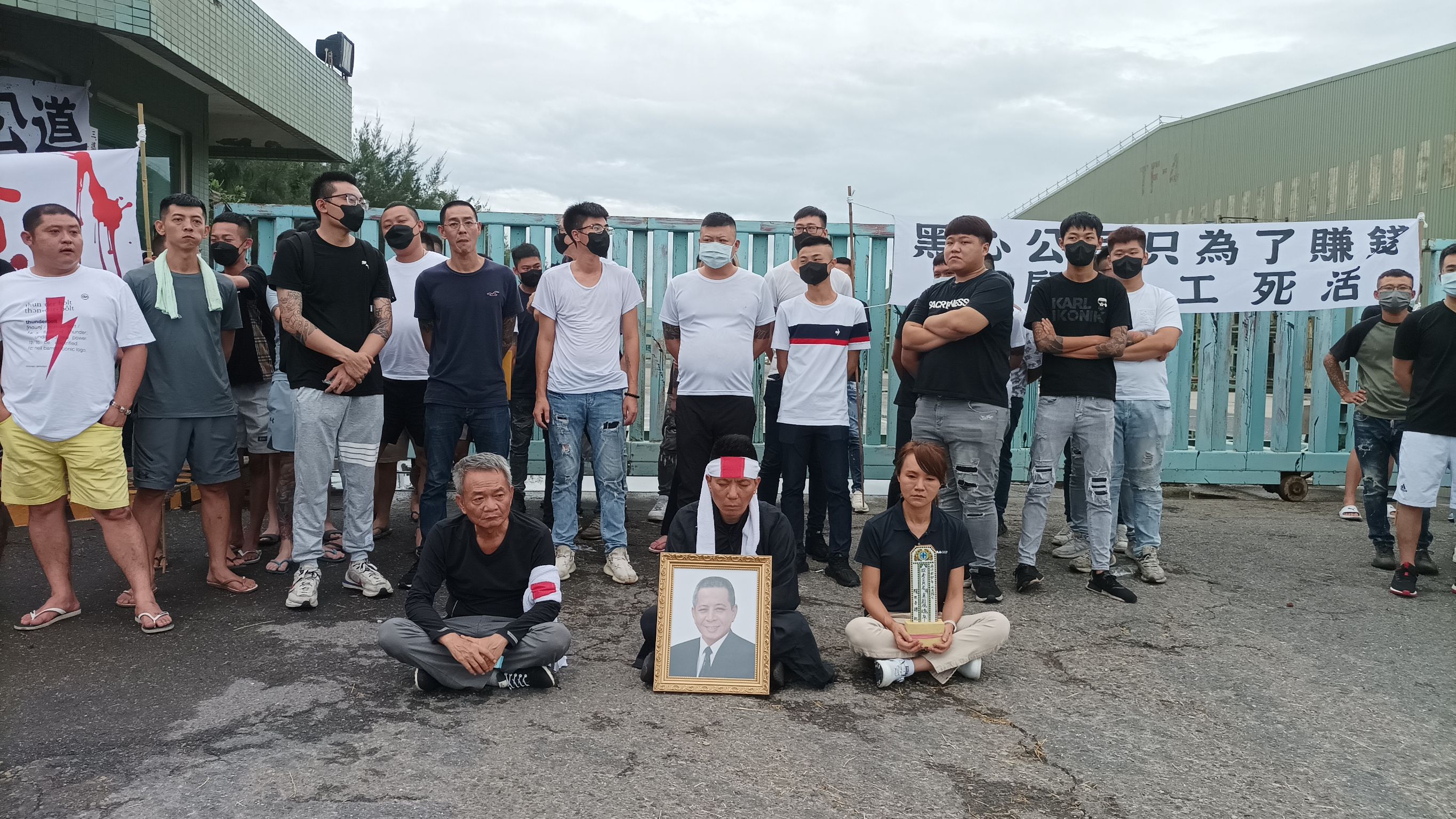 台玻公司員工黃男家屬集結百名親友，至該公司鹿港廠拉白布條抗議。（讀者提供）
