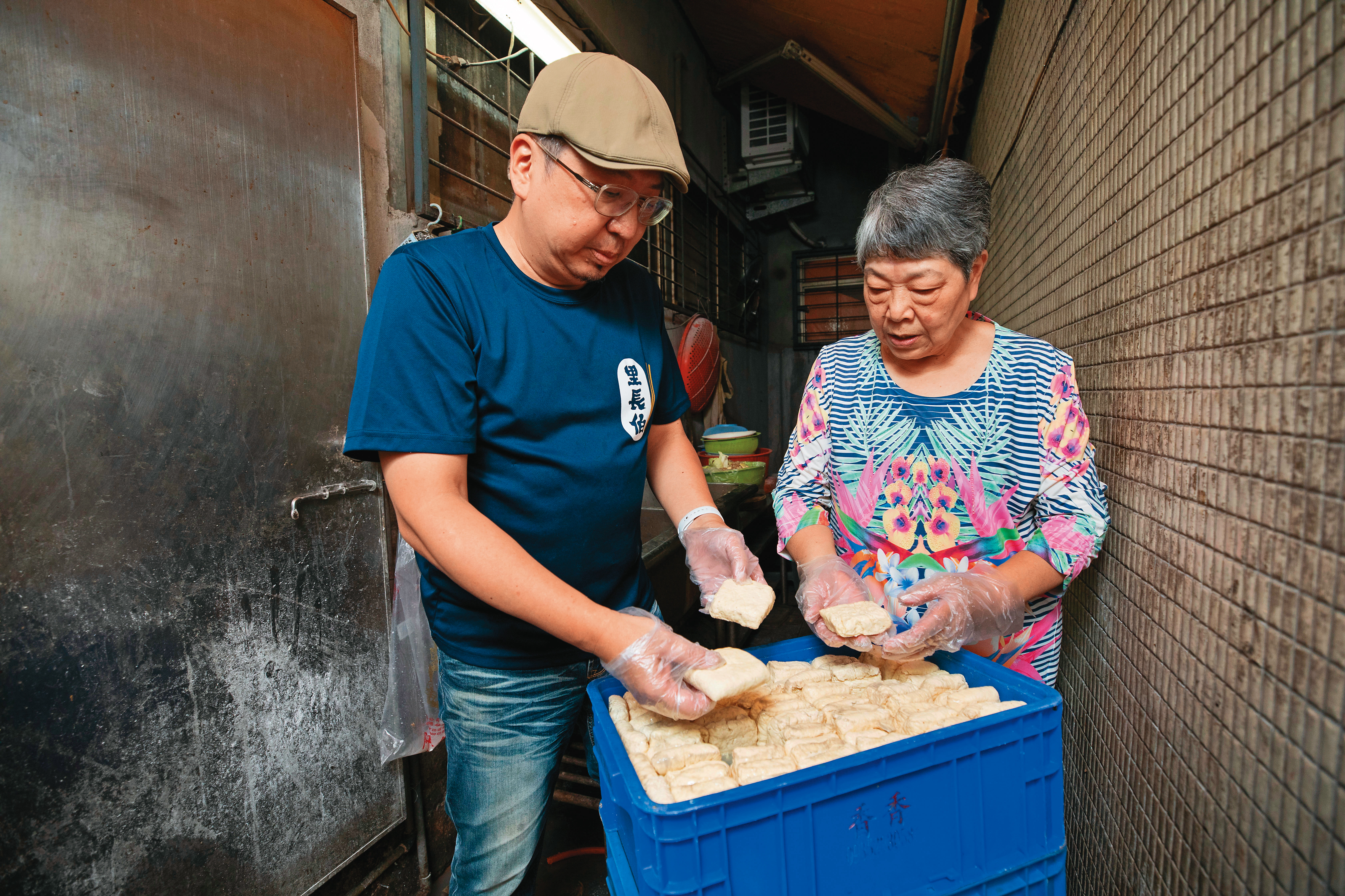 方寶銀（右）將家傳料理的祕訣傳給兒子李啟榮（左），老店至今都選用成本較高的非基改黃豆做臭豆腐。