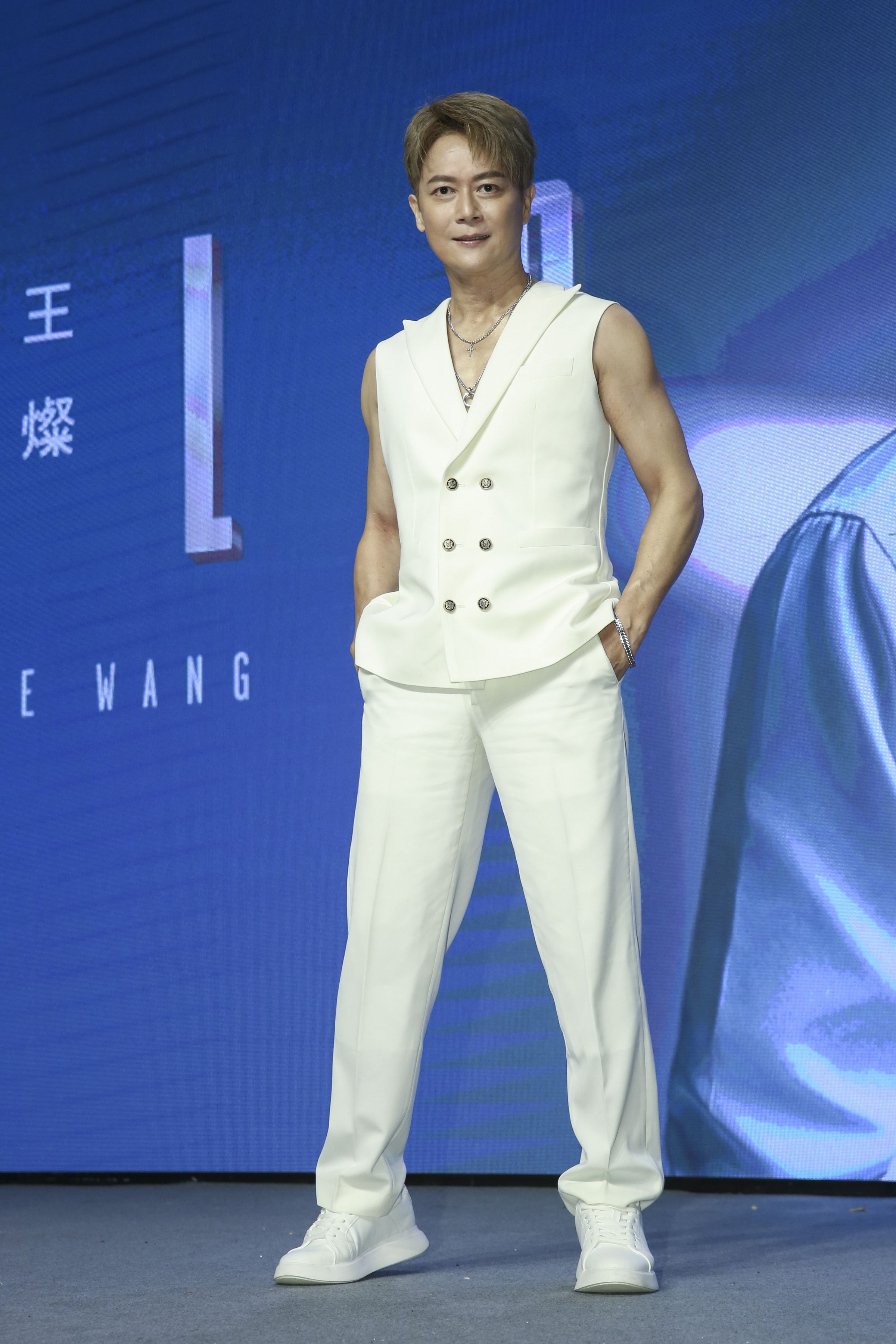 王燦身穿白色背心，大方秀出臂肌與胸肌。