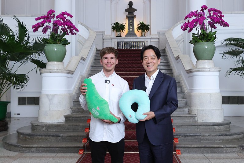 來自斯洛伐克的攝影師Patrik Paulínyi入住總統府,賴清德親自送上兩用的台灣造型抱頸枕。(總統府提供)