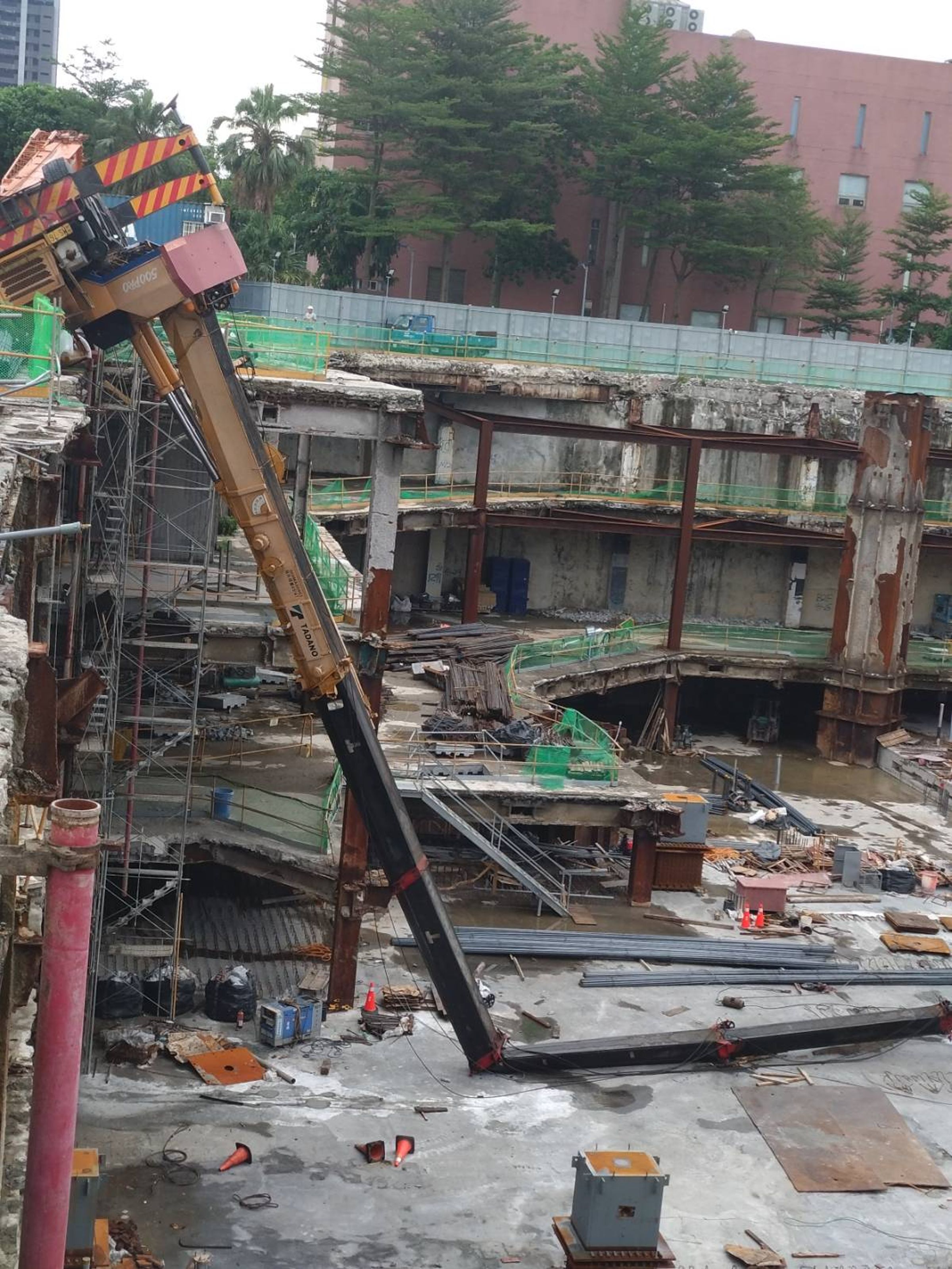 台北市京華城舊址工地發生工安意外，施工吊車上午在工地頂樓翻覆，駕駛一度受困車內。（翻攝自記者爆料網）