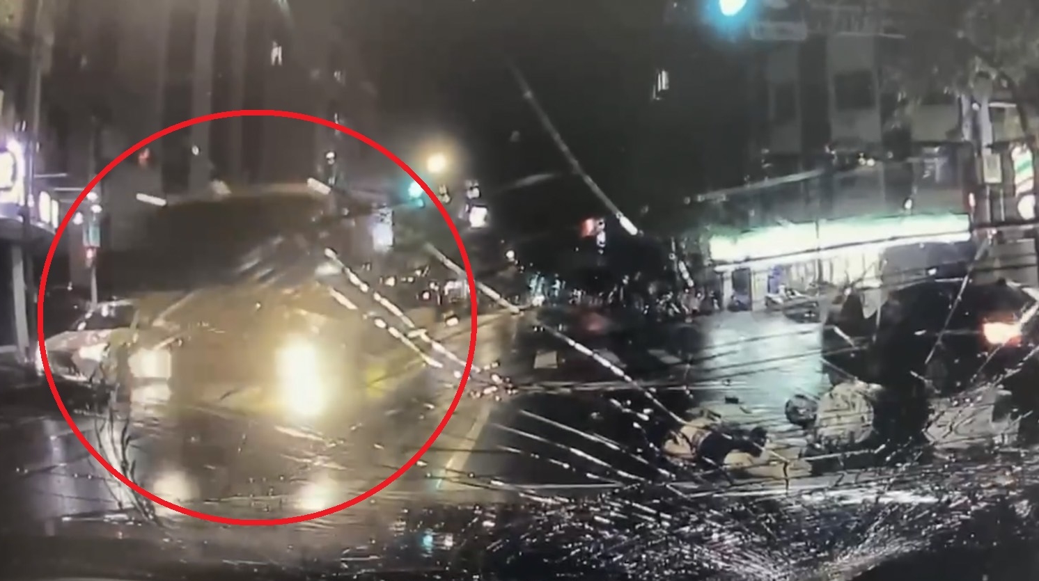 顧男被撞後，倒臥在對向車道上，不幸又被恰巧經過的拖吊車（紅圈）輾過。（翻攝畫面）