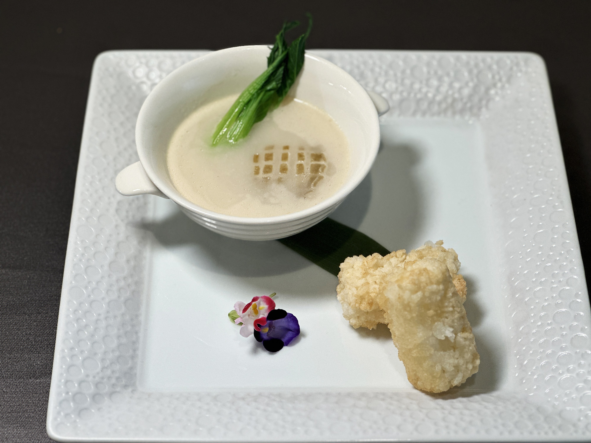 「魚湯原粒鮮鮑炸飯糰」的精髓是製作繁複的鮮濃奶白色魚湯，可將酥脆鍋巴飯條蘸入魚湯一起享用。