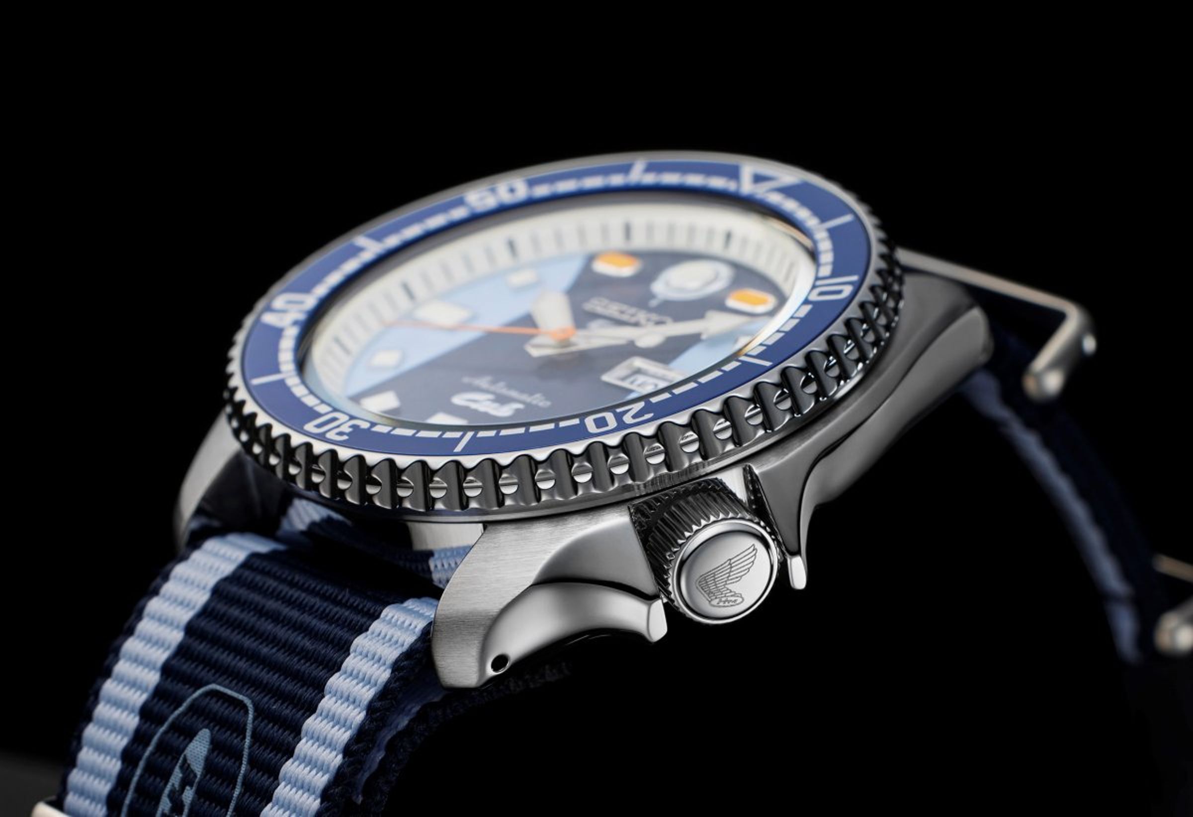 SEIKO 5 Sports X HONDA Super Cub限量錶款，四點鐘錶冠位置印有HONDA「自由之翼」廠徽。