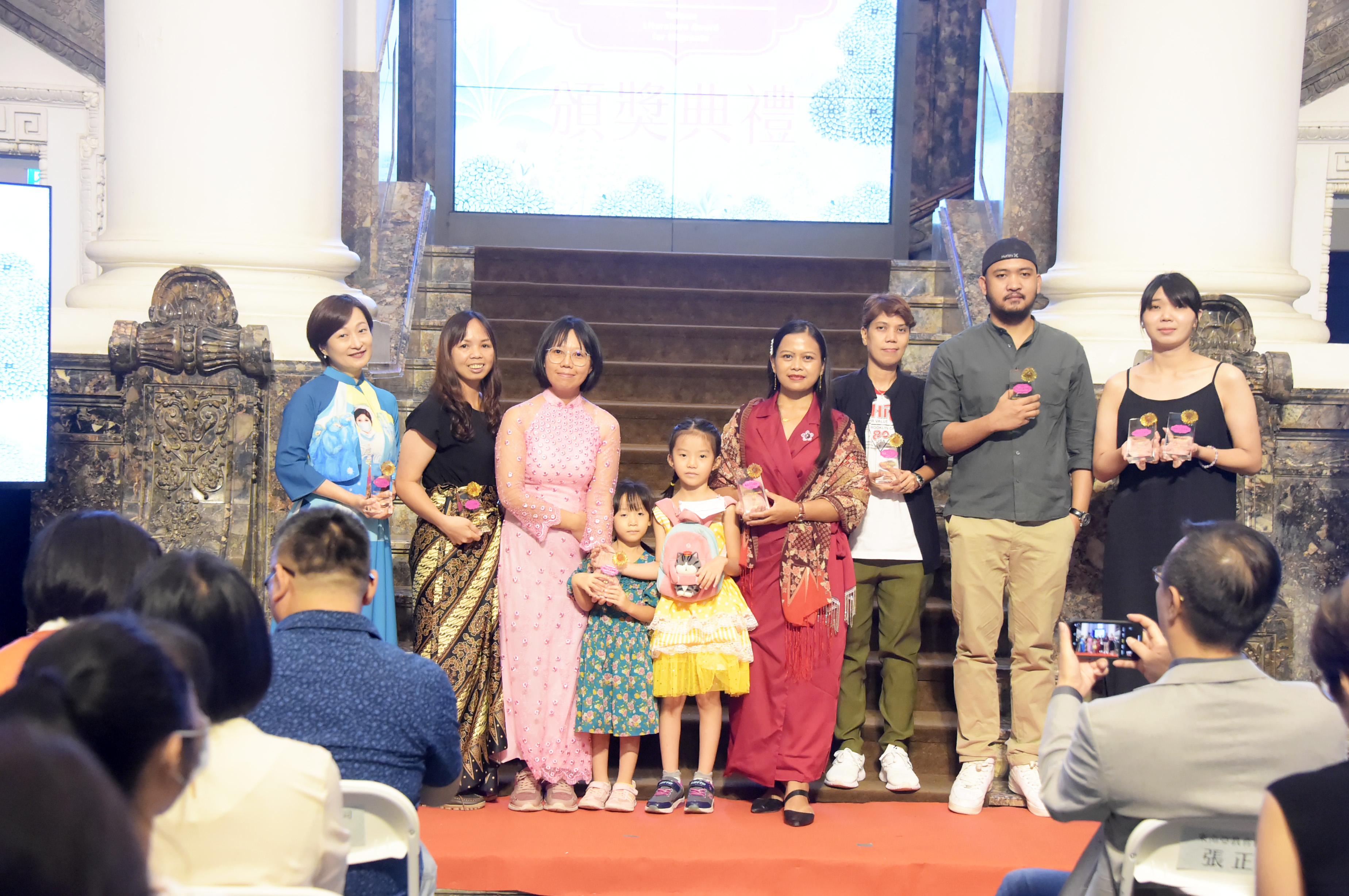 第八屆移民工文學獎頒獎典禮在國立臺灣博物館舉行，得獎者由左至右：廖雲章（阮日輝代領人）、陳業芳、武豔秋、莉莉、米玲達、Roniel D. Molina、盧詩雁（陳孝珍代領人）。