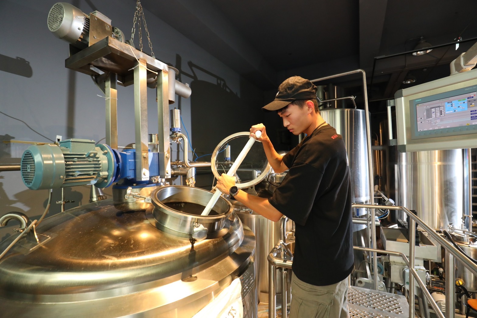 釀酒師正在進行「糖化」作業,將熱水與碾碎的麥芽攪拌混合。