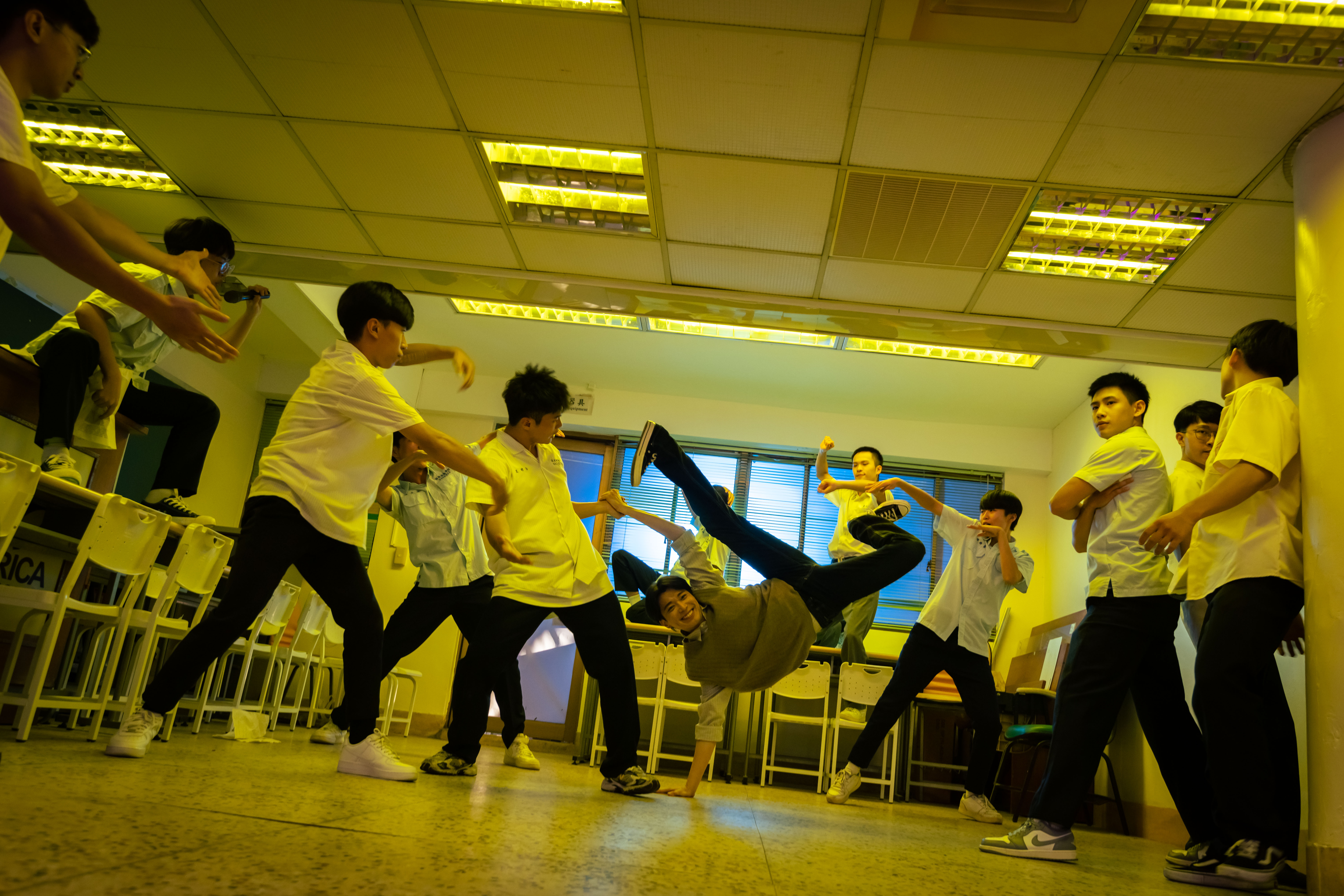 《成功補習班》全片穿插張國榮金曲〈Monica〉，片尾更邀請全體演員一同尬舞，侯彥西（中）表演高難度的地板動作。（華納兄弟提供）