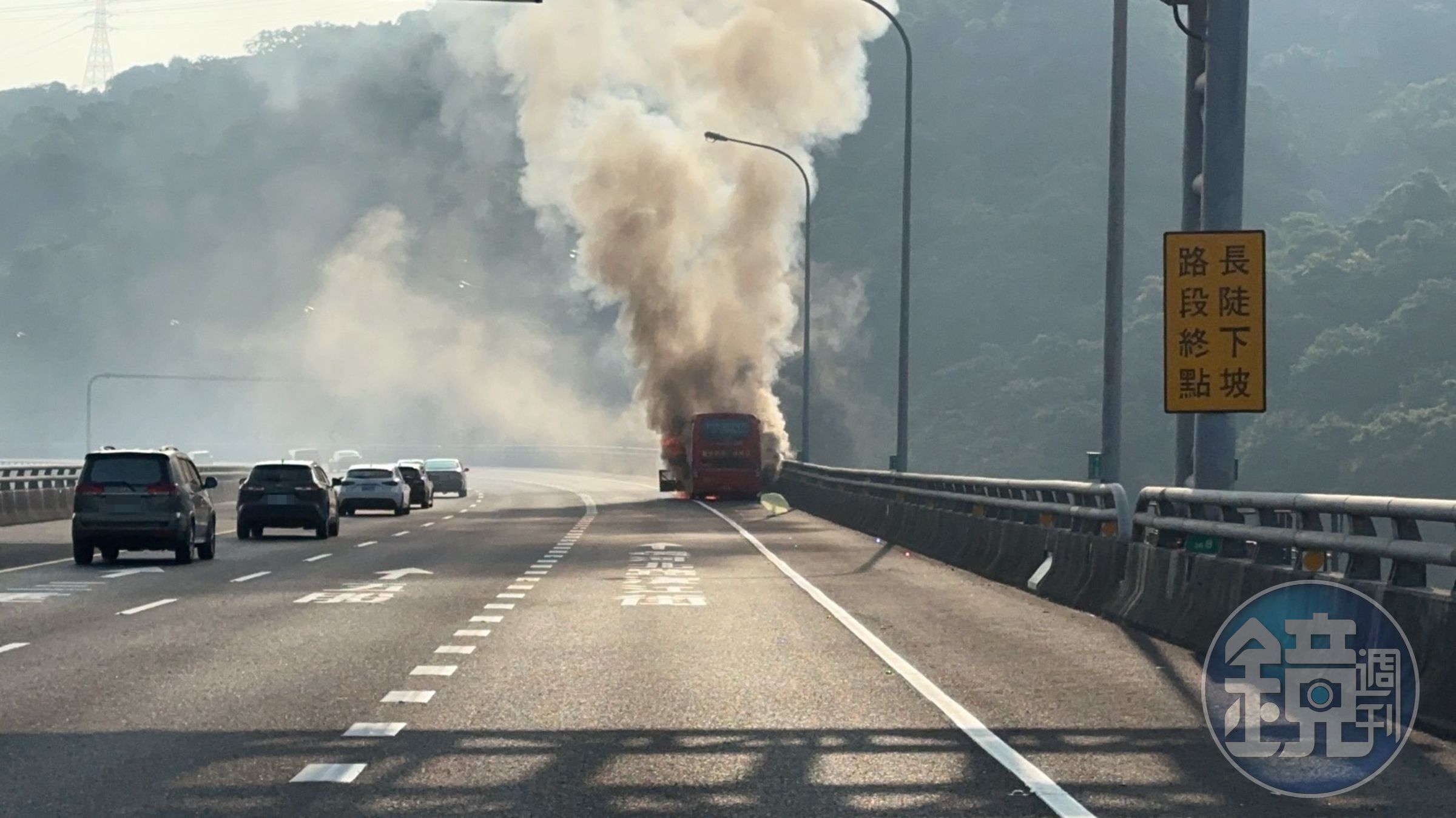 遊覽車董姓駕駛發現車輛冒煙,緊急將車停靠路肩,車輛隨即起火燃燒。(翻攝畫面)