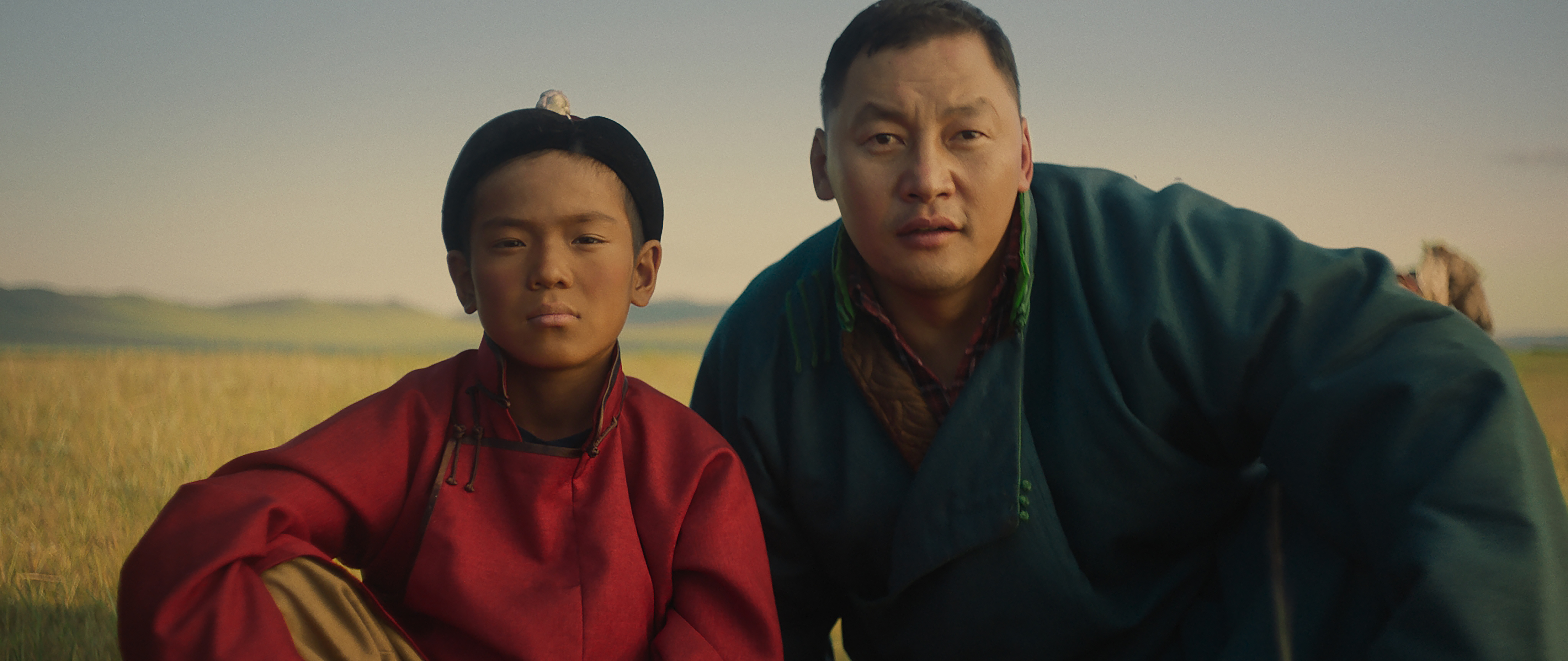 阿木爾賽汗（右）自編自導自演《愛在滿格時》，費時3年找到10歲的特努恩額爾盾（左）。（佳映娛樂提供）