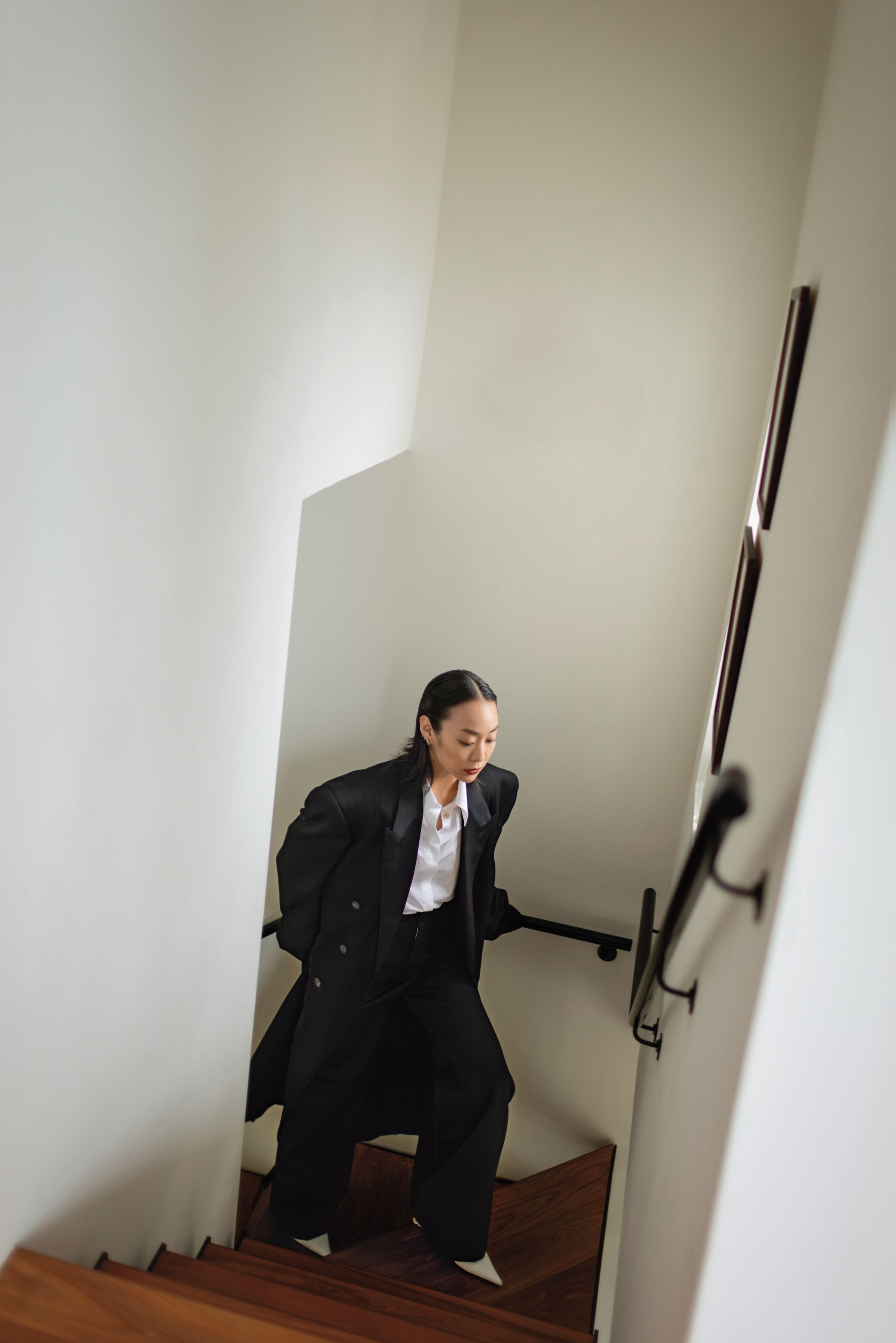 黑色長大衣，NT$173,000，by BALENCIAGA；白色襯衫，NT$29,000，by GUCCI；黑色高腰羊毛長褲，NT$39,000，by LOEWE；Anagram白色尖頭跟鞋，價格店洽，by LOEWE。