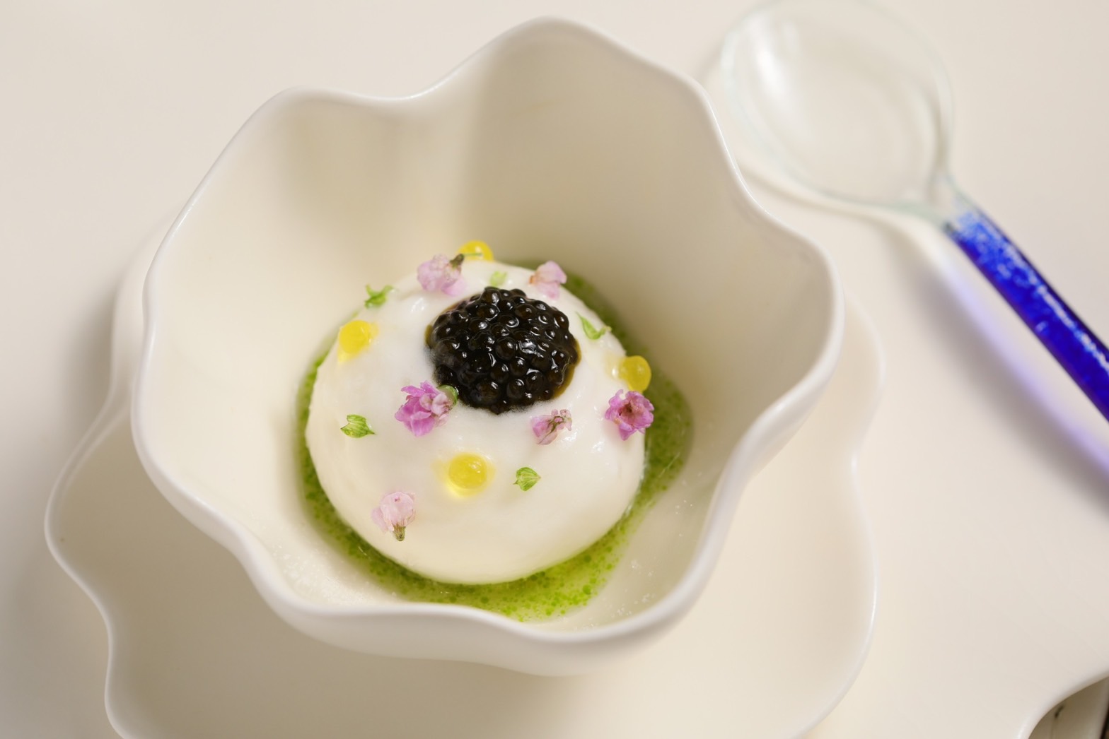 「白的點線面：盛夏的白」分為兩道餐點，這道amuse bouche開胃菜呈現白蘆筍食材的細節和多樣性，白蘆筍泡泡上方擺上橄欖油魚子醬、裡層包覆著豆漿冰淇淋，展現出蘆筍的清甜與海的鮮味。