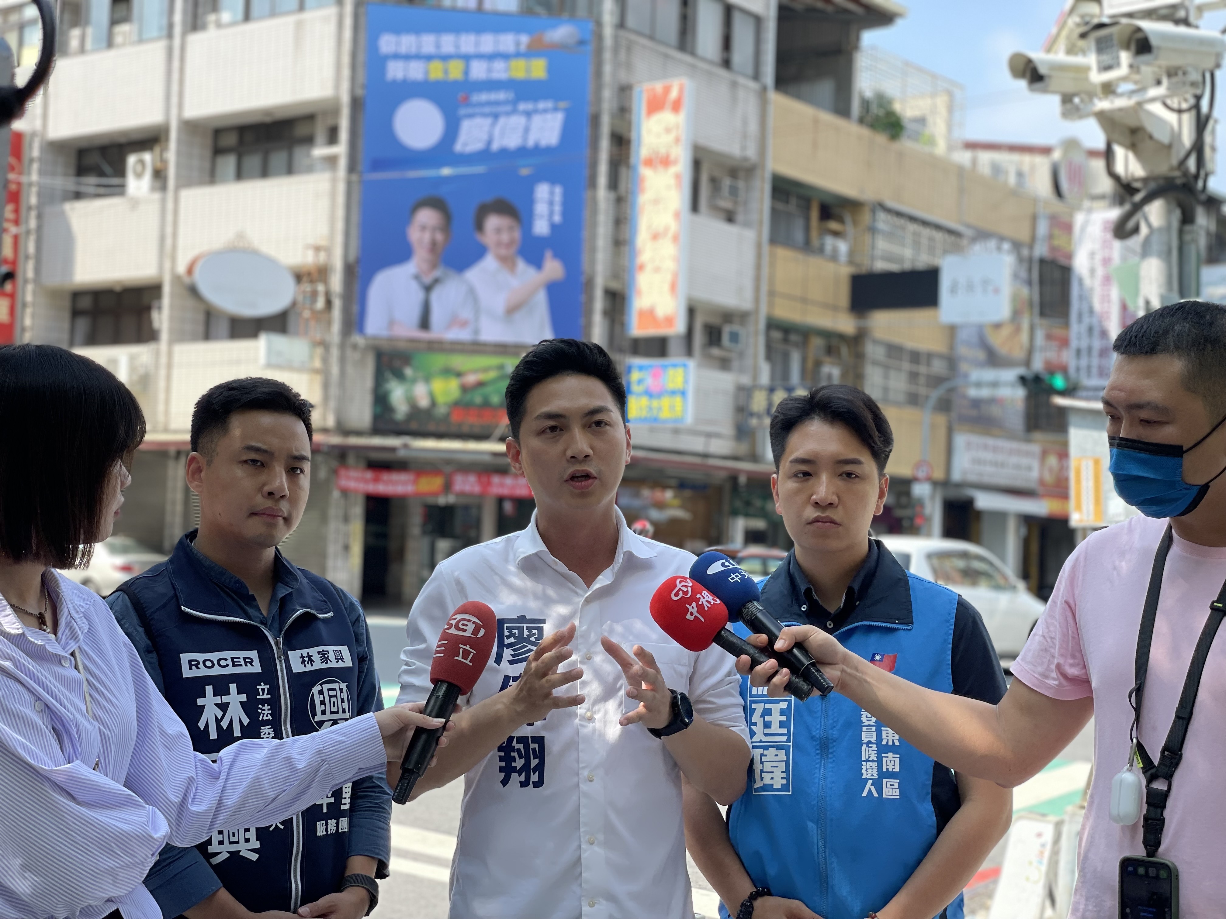 國民黨台中市立委參選人廖偉翔等3人，9日在台中市南屯區掛上全台首面護食安看板。（國民黨立委參選人廖偉翔提供）