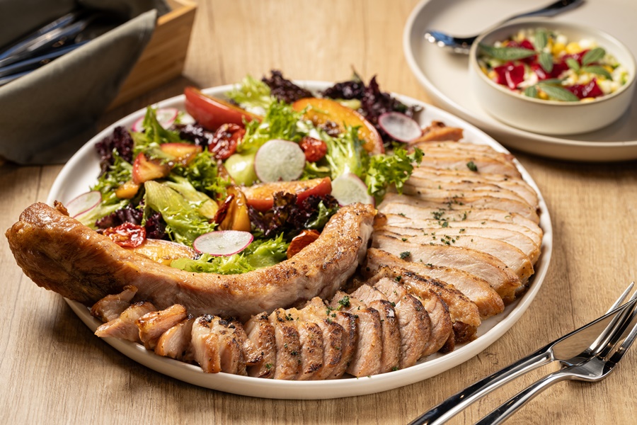 TOK的招牌排餐是「嫩煎戰斧豬排佐蜜蘋果」，不但豬排軟嫩，旁邊的烤蘋果與沙拉的酸甜度也搭配得恰到好處。（1,180元／份）