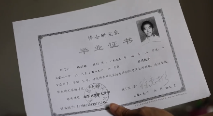 張炘煬拿出自己的博士畢業證書。(翻攝九派新聞微博)