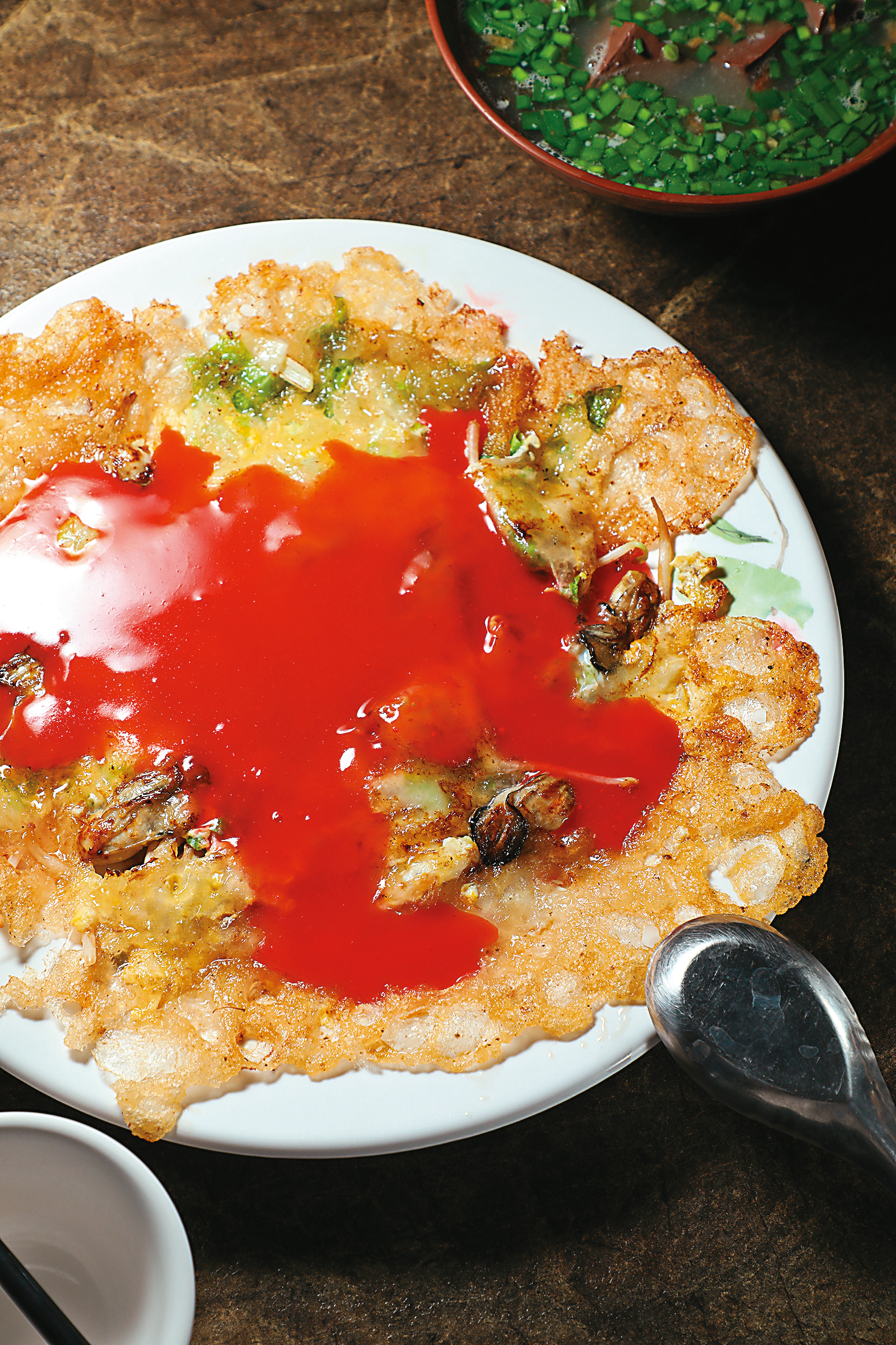 比臉大的「蚵仔煎」，酥香薄脆的邊緣是一大亮點，醬料也是加米漿自製。（80元/份）