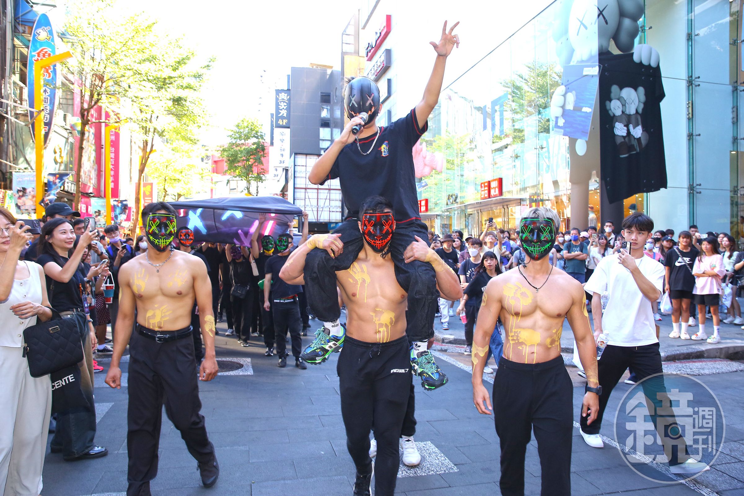 西門町街頭百名黑衣人齊聚,大聲吆喝、舉布條、丟水球,引起民眾圍觀熱議。(官方提供)