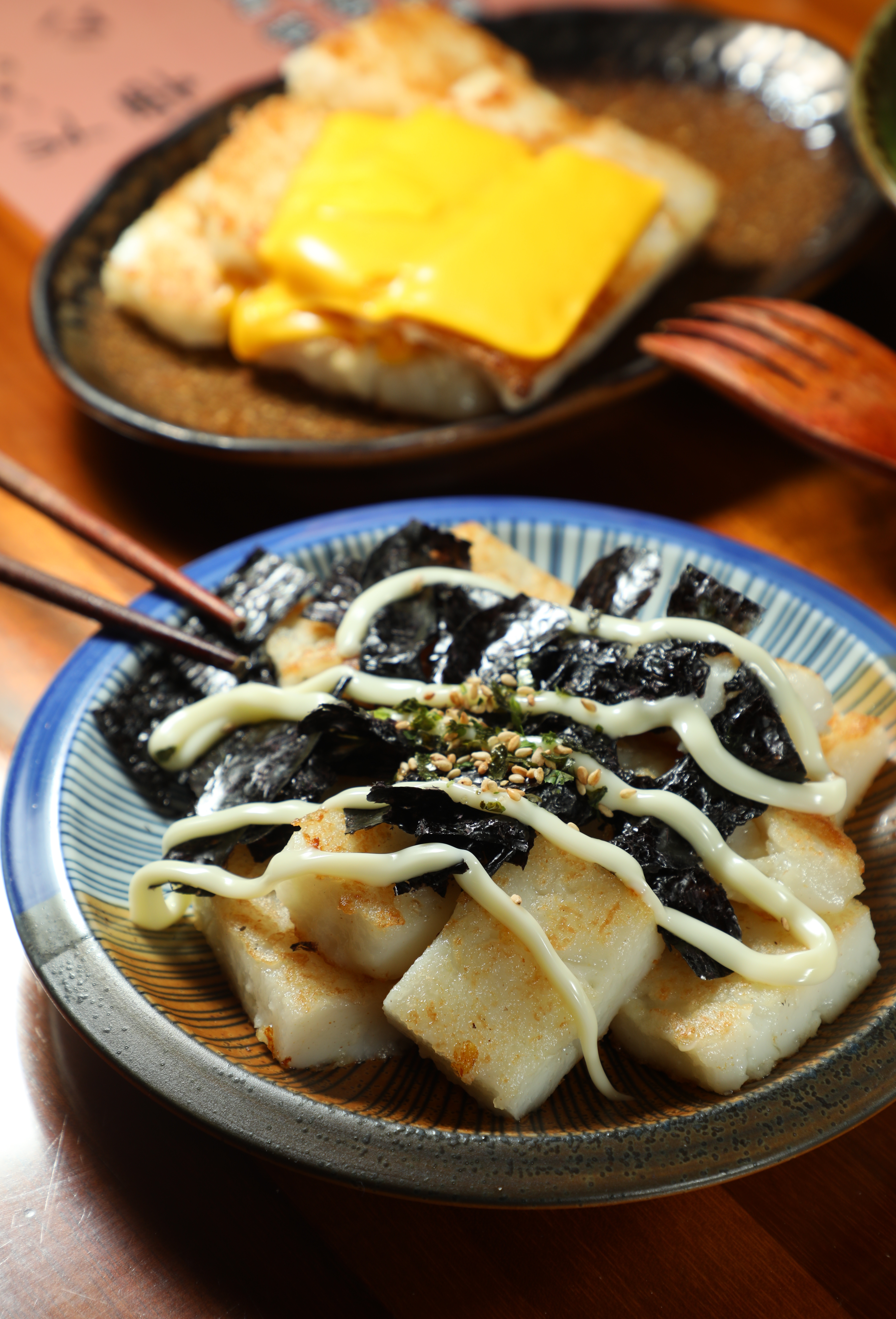 「日式海苔」（前，65元／份）與「雙倍起司」（後，75元／份）都是受年輕客人歡迎的新口味蘿蔔糕。