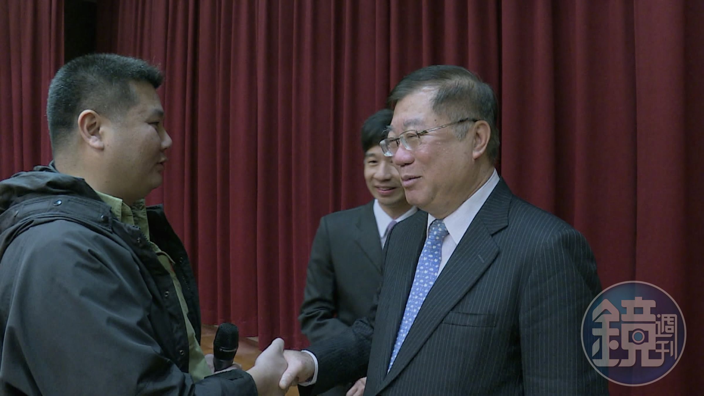 李惠仁（左）現身時任農委會（現為農業部）主委陳保基（右）的卸任歡送會，並抓住機會追問禽流感疫情失控的議題。（公視提供）