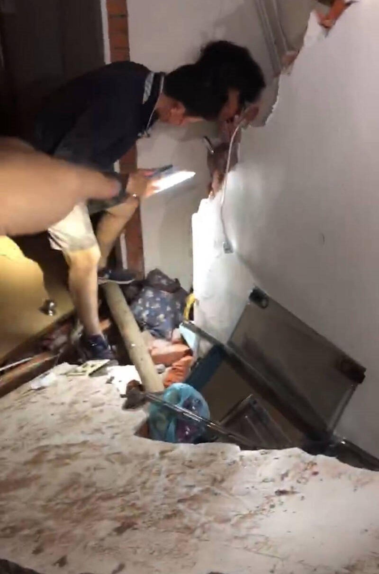 台南楠西民族路一棟民房倒塌，消防人員救出受困的一對夫妻與幼兒。（台南市政府提供）