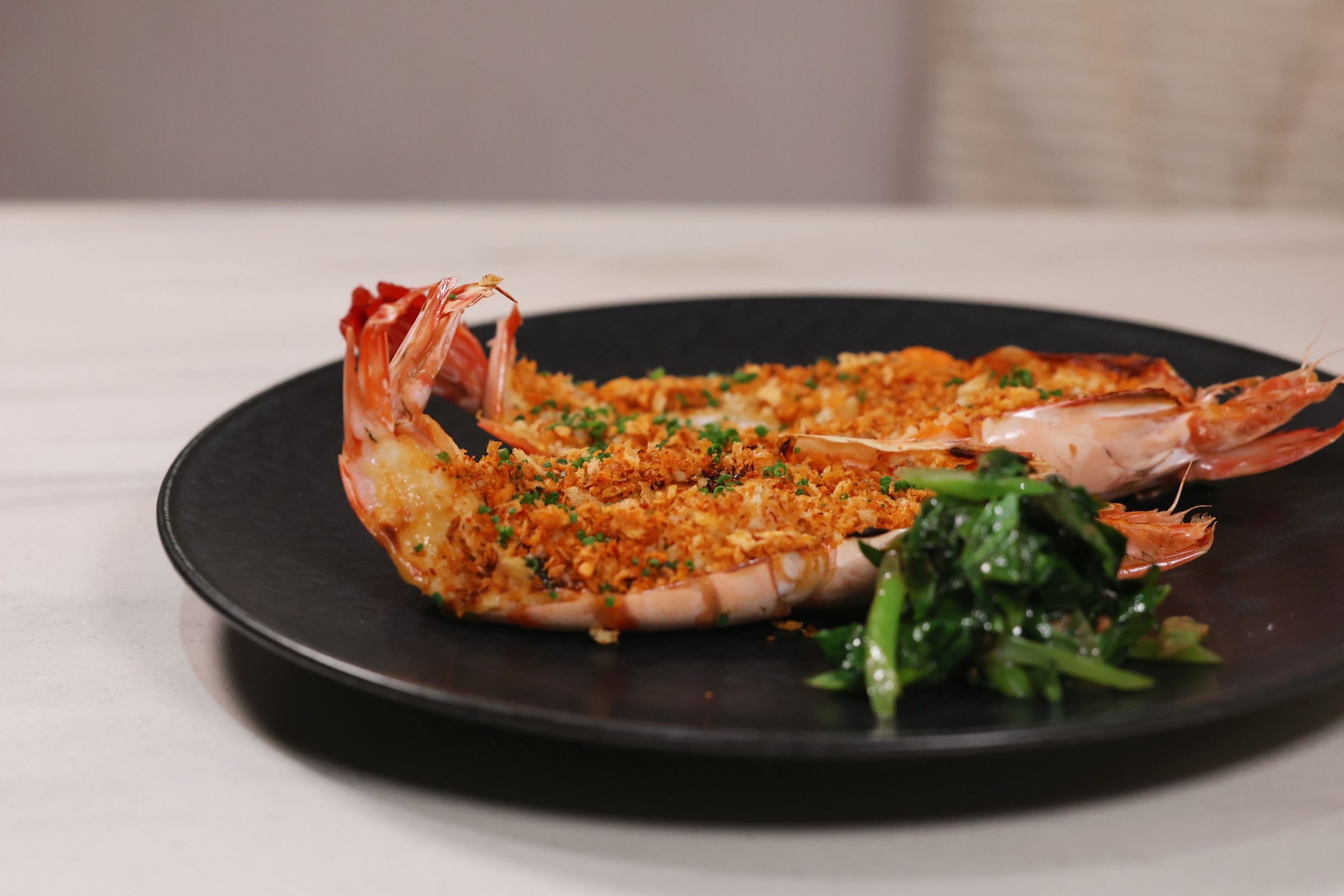 「炙烤虎蝦、大蒜、芥藍、鹹蛋黃醬汁」結合焗蝦、避風塘與金沙等道地港式元素。（1,280元／份）（Golden提供）