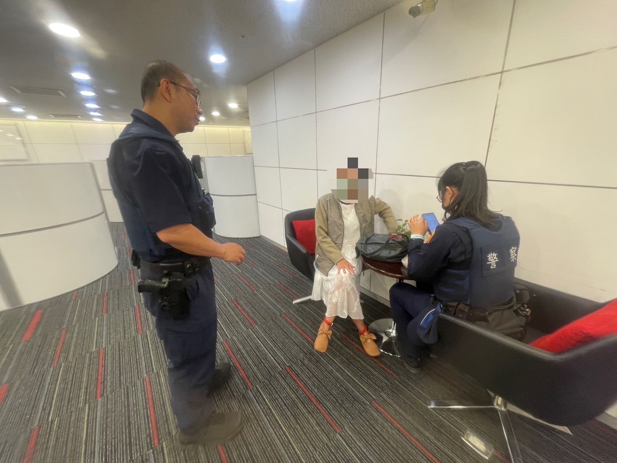 婦人「阿珠」到銀行臨櫃辦理海外匯款,行員察覺有異,與警方一起委婉說明。(翻攝畫面)