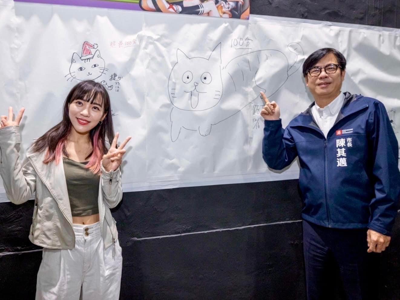 民進黨立委參選人黃捷（左），與高雄市長陳其邁（右）出席「2023高雄駁二動漫祭」開幕活動，比出貓咪動作。（翻攝畫面）