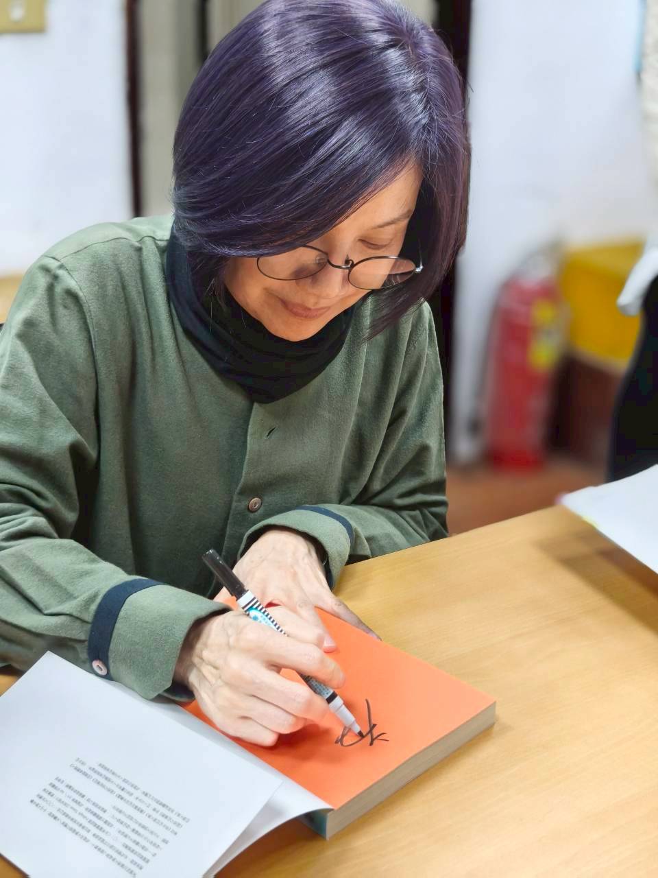 唐美雲簽名時笑說像被罰寫名字。(紙風車劇團提供)